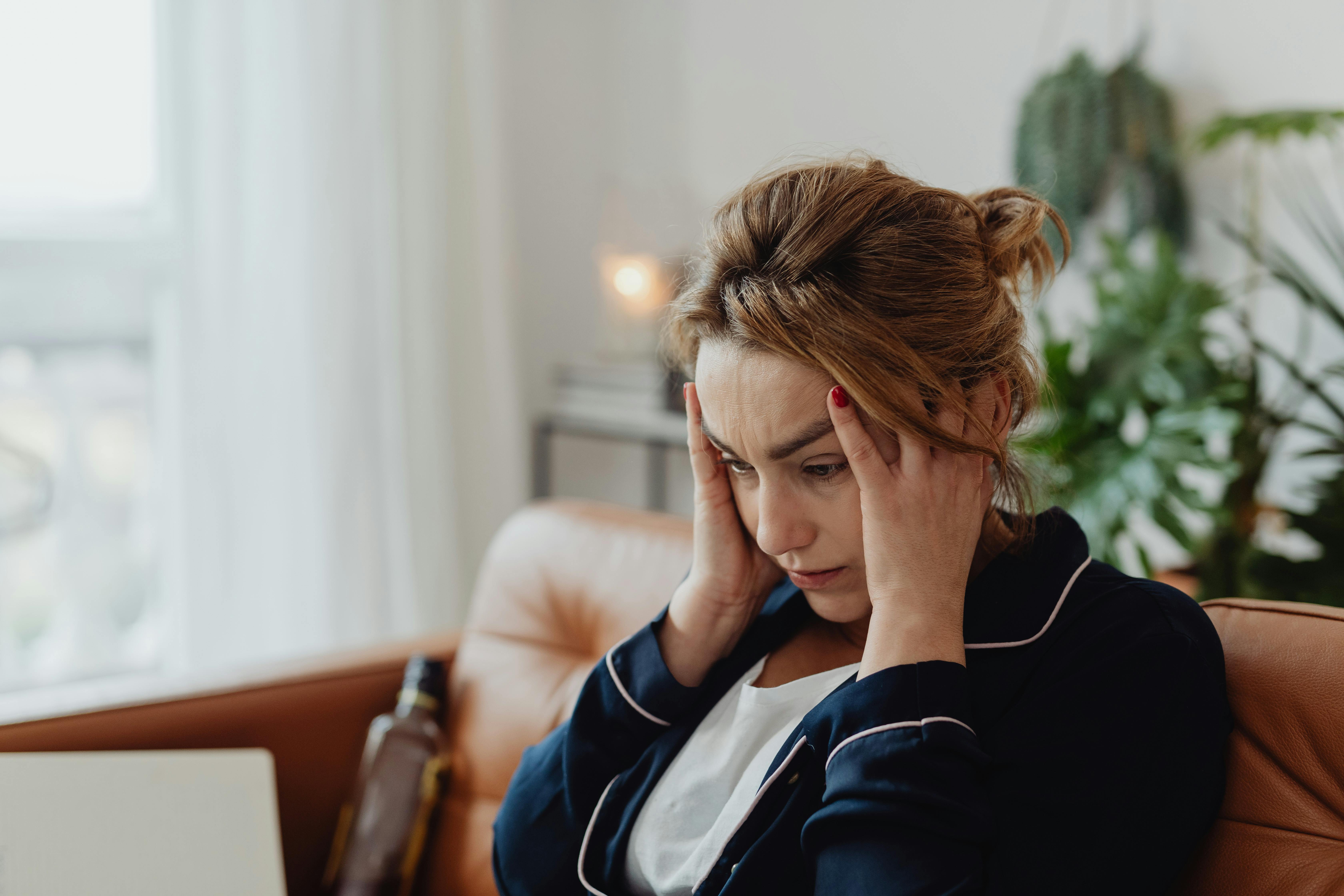 A woman holding her head | Source: Pexels