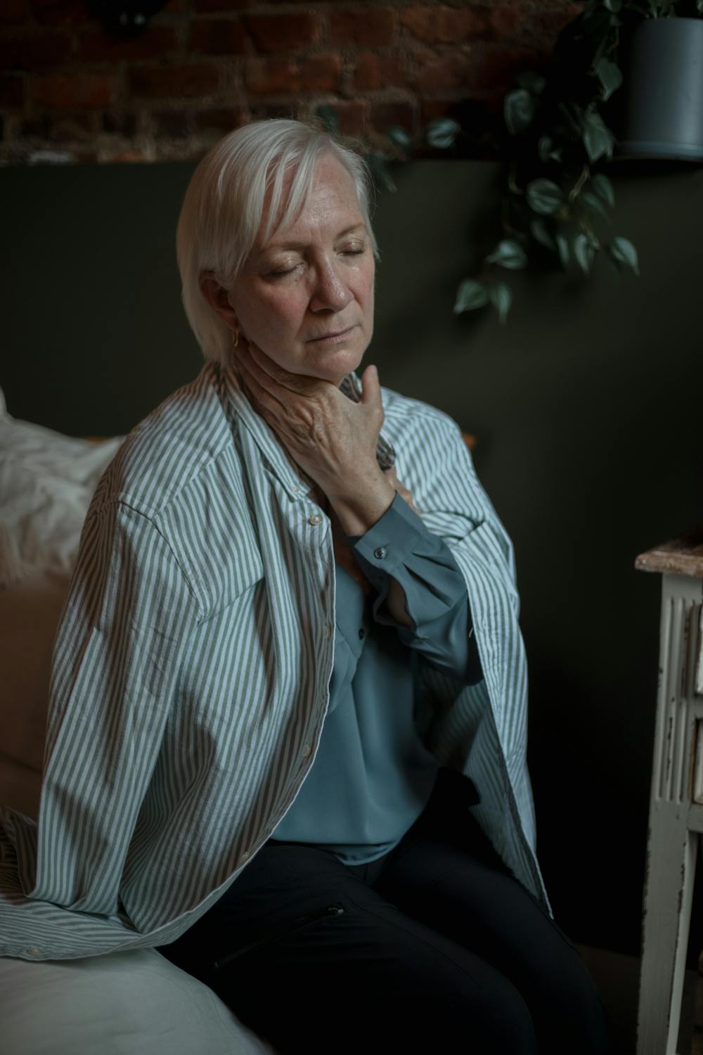 A serious woman sitting on her bed | Source: Pexels