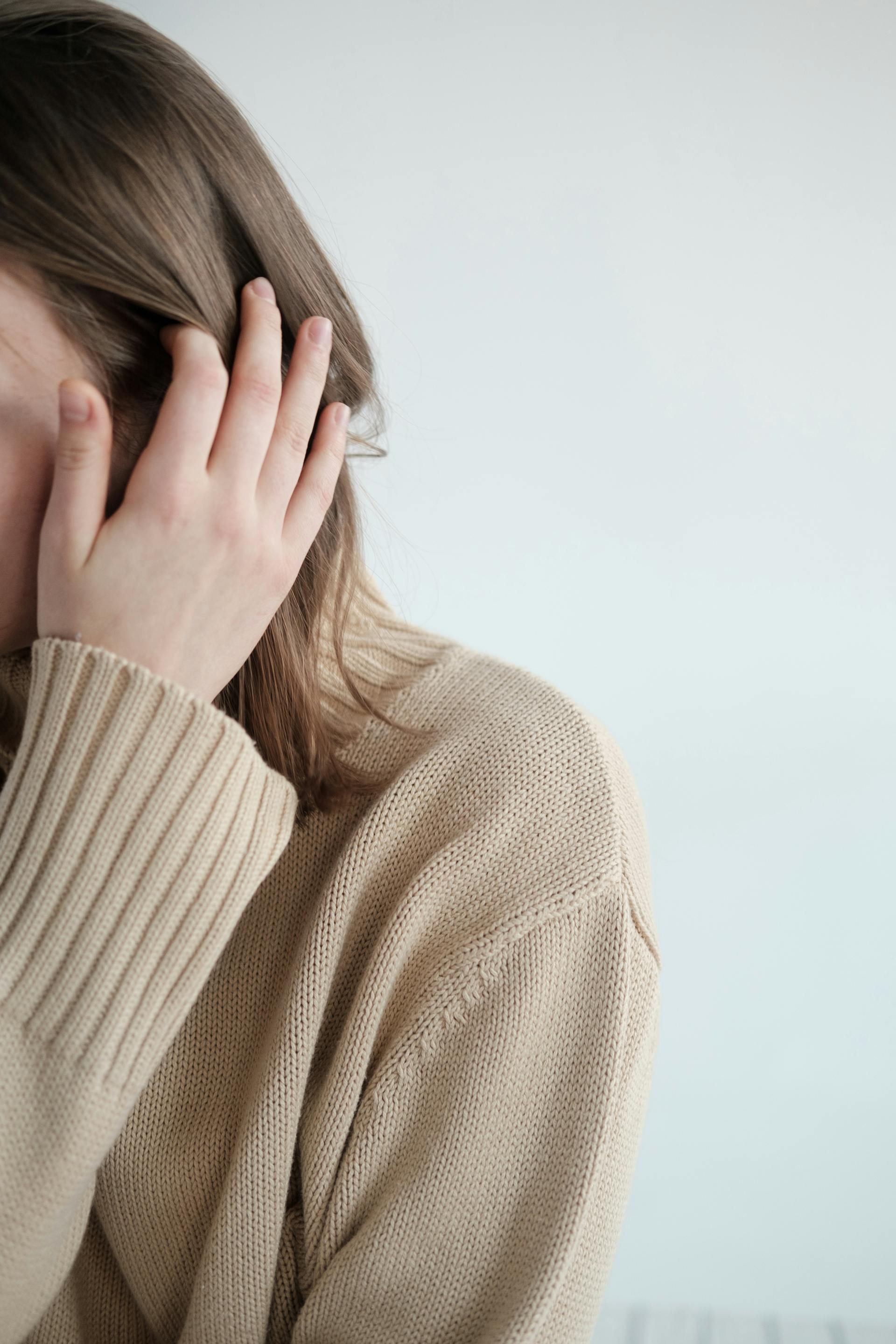 A close-up shot of a woman touching her hair | Source: Pexels
