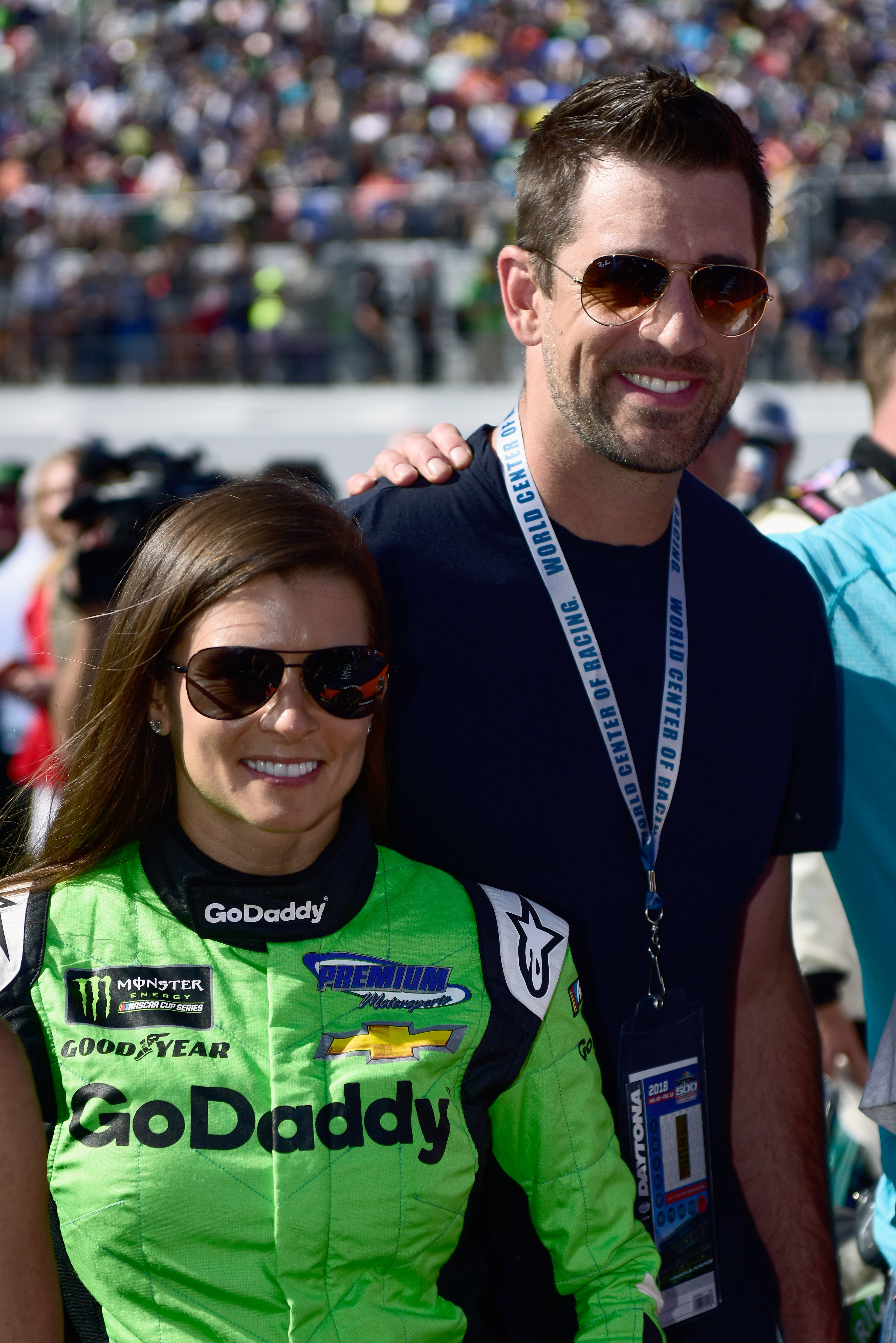 Danica Patrick, driver of the #7 GoDaddy Chevrolet, stands with Aaron Rodgers, quarterback for the Green Bay Packers, on the grid prior to the Monster Energy NASCAR Cup Series 60th Annual Daytona 500 at Daytona International Speedway on February 18, 2018 in Daytona Beach, Florida. | Source: Getty Images