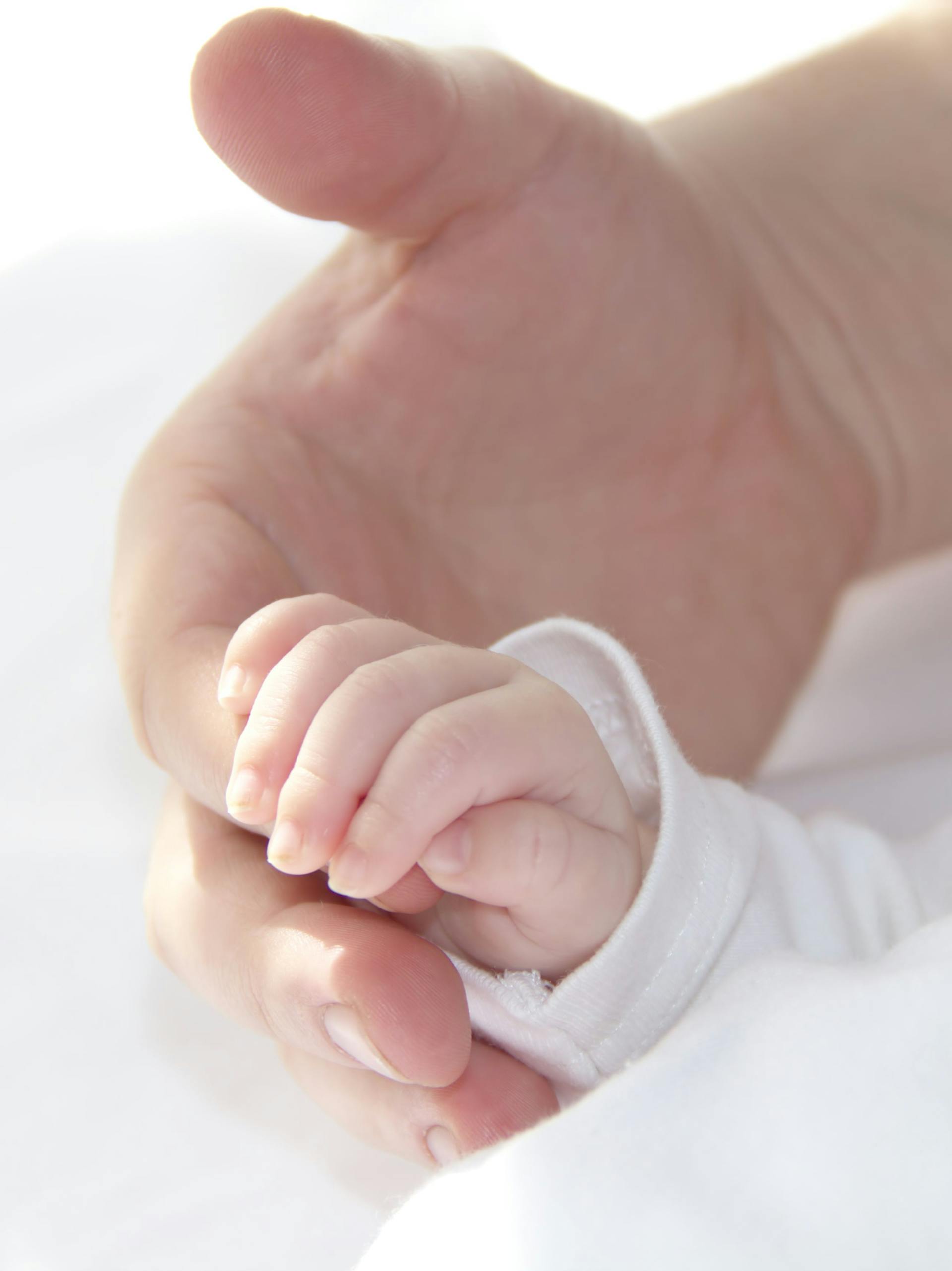 A baby holding a man's finger | Source: Pexels