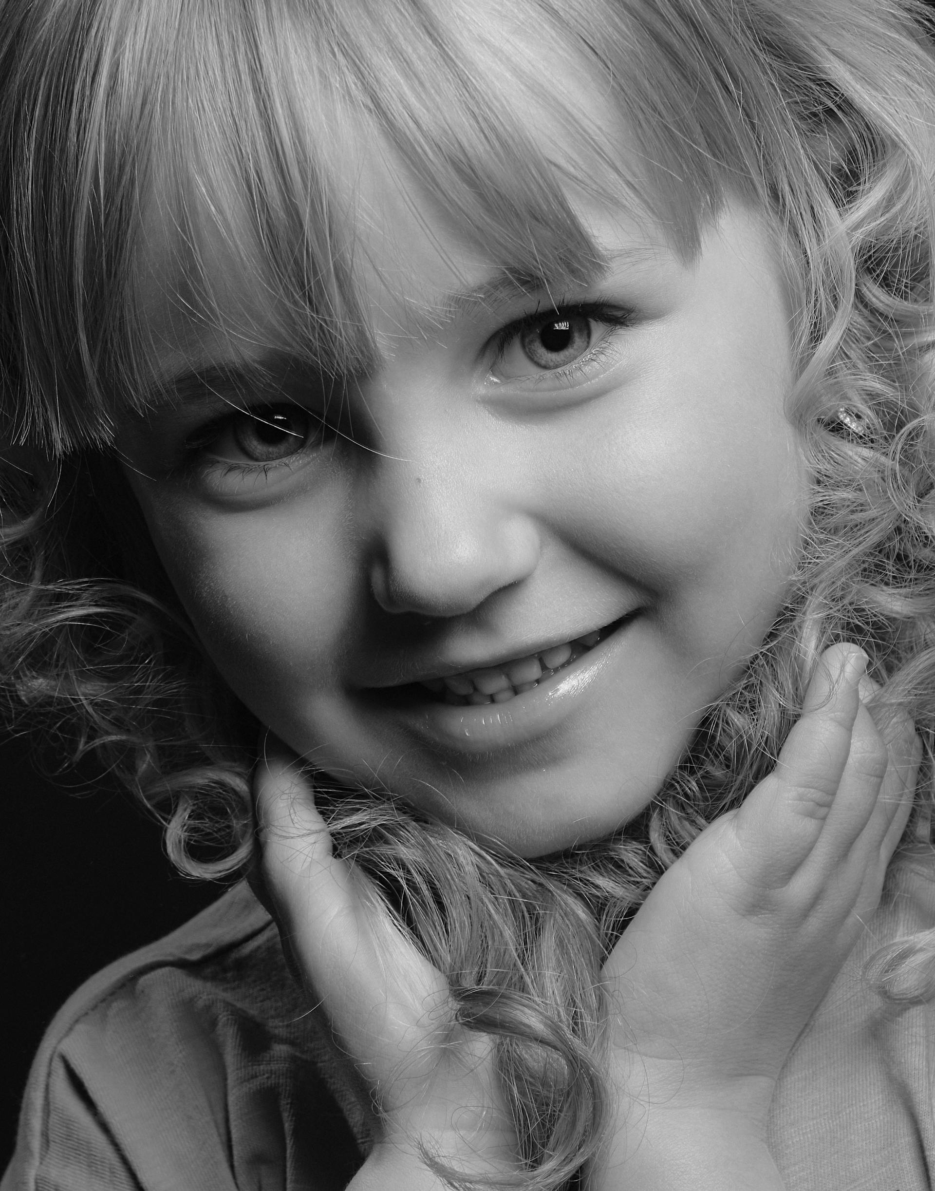 A grayscale photo of a smiling little girl | Source: Pexels