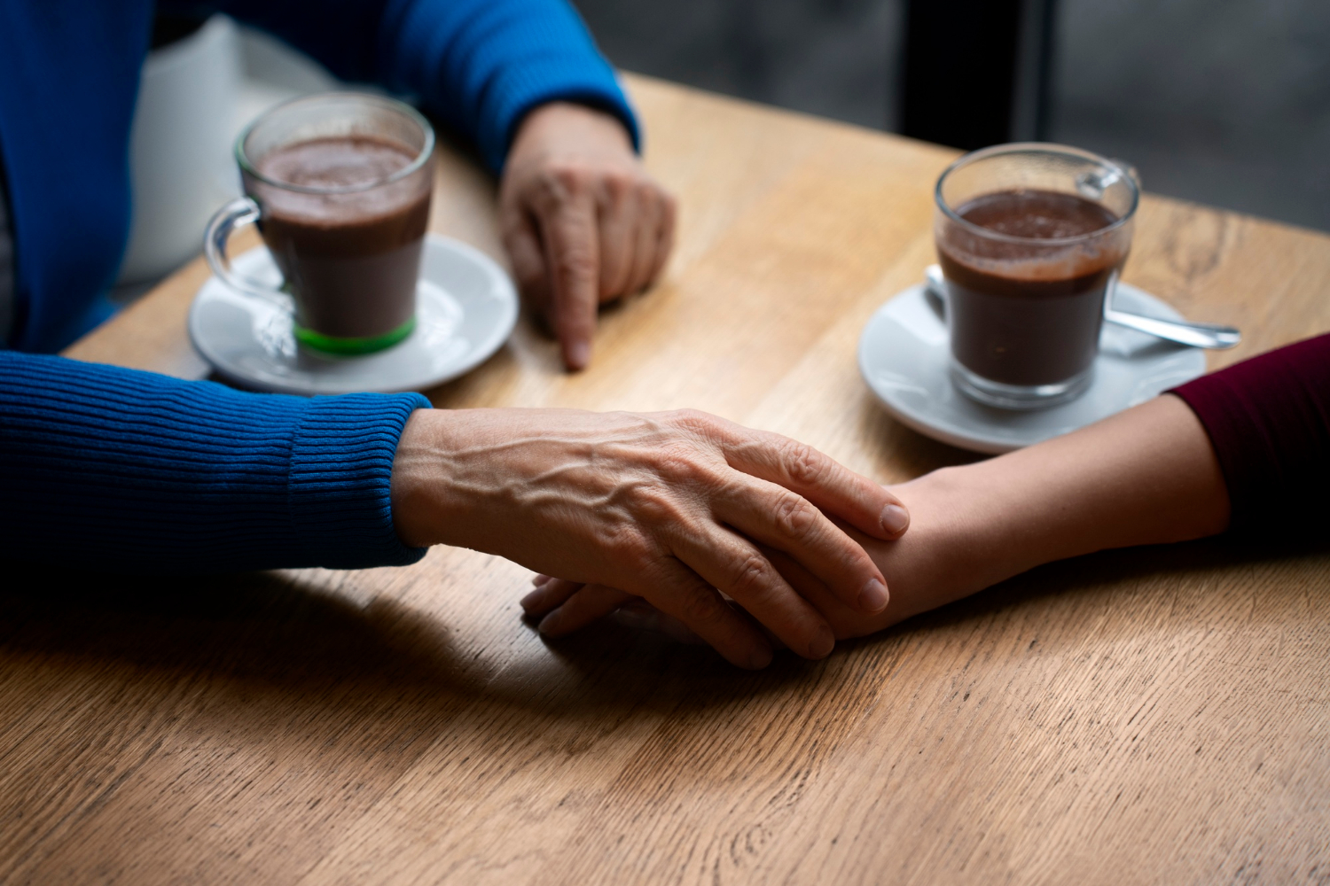 An older woman holding a young woman's hand | Source: Freepik