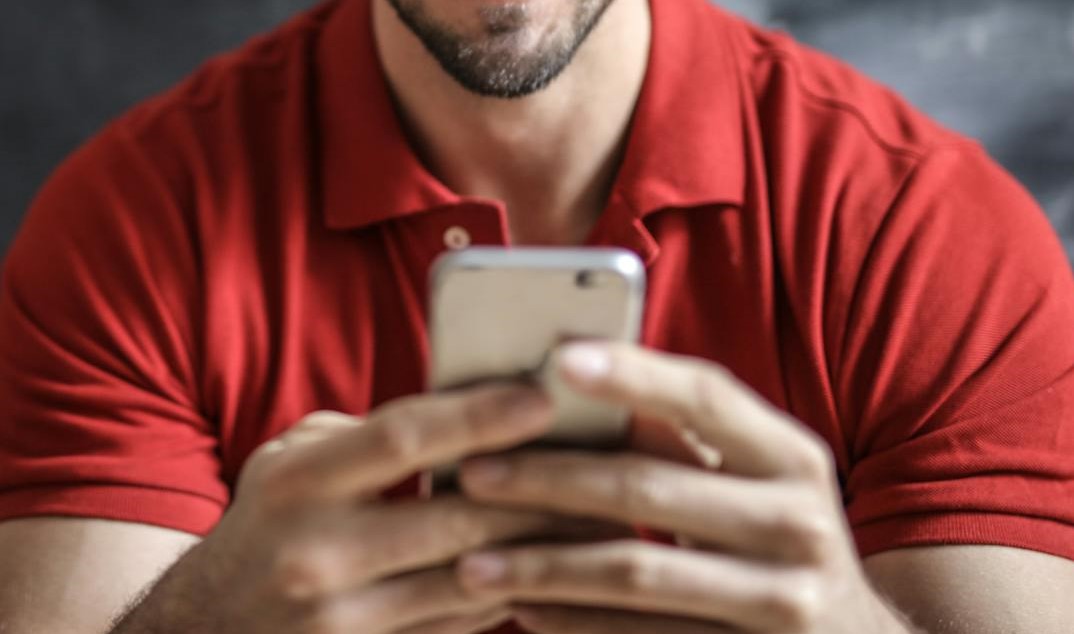 Close-up of a man holding a smartphone | Source: Pexels