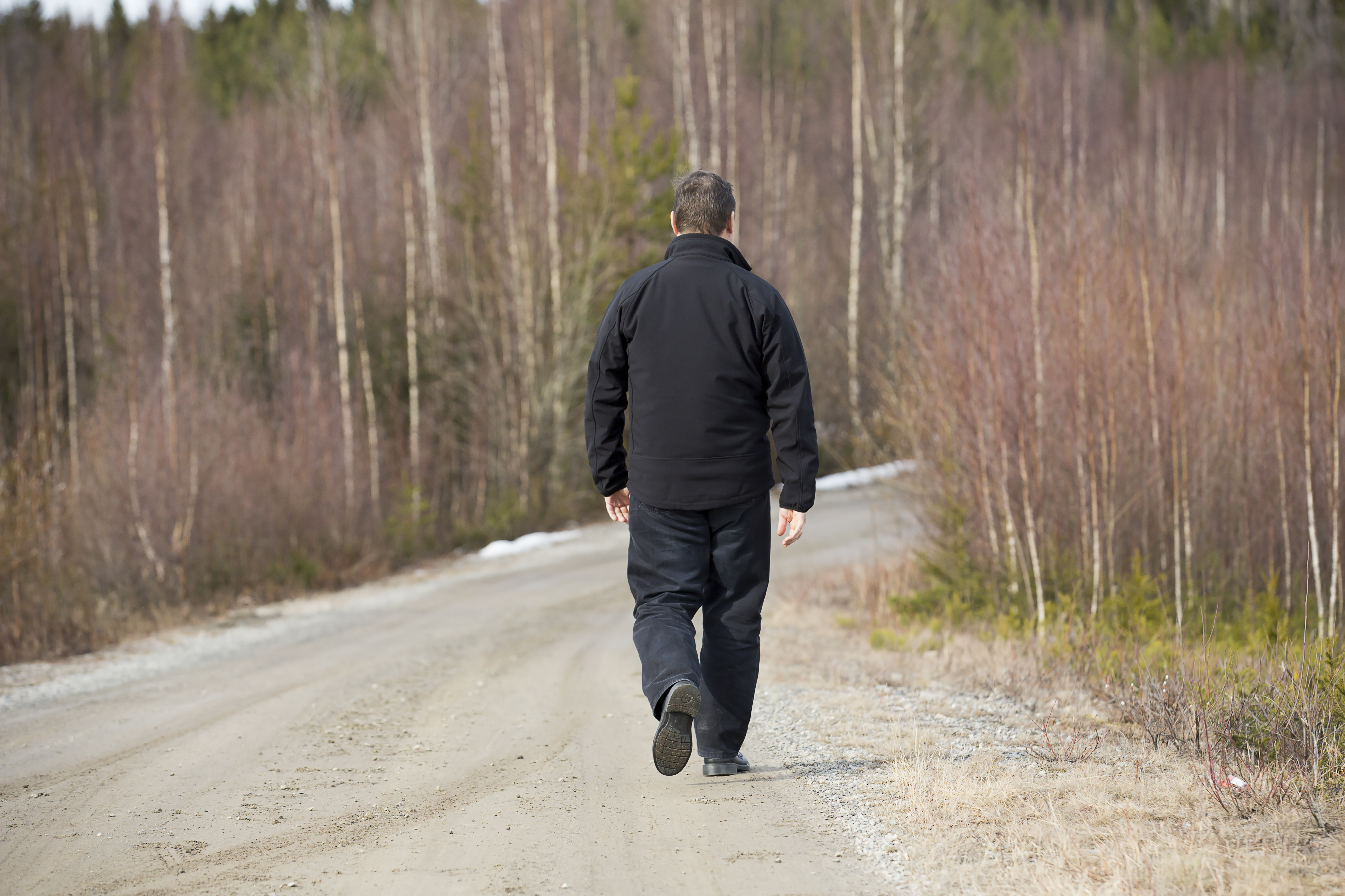 Man Walking On Road. | Source: Shutterstock