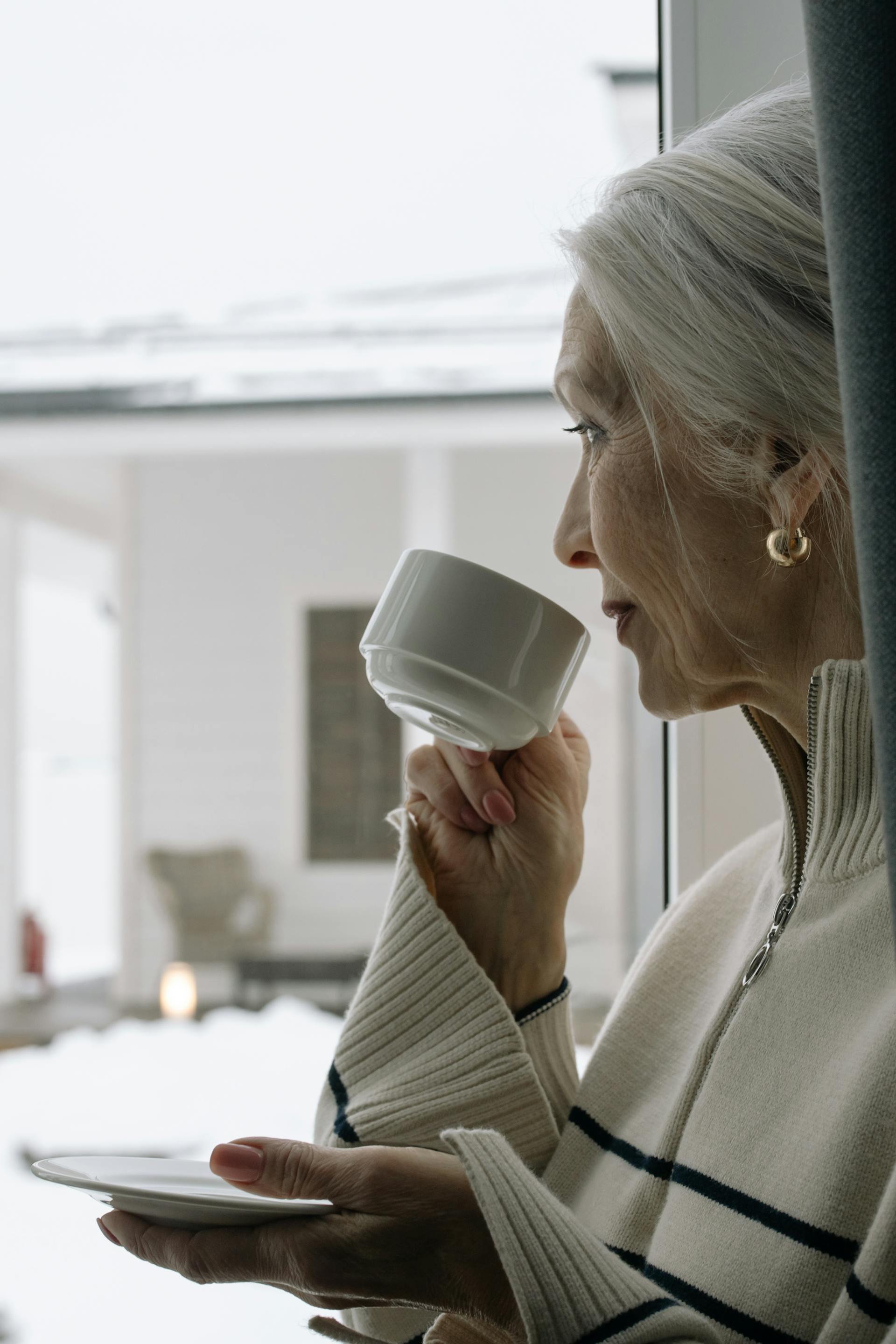 A woman smiling faintly while looking out a window | Source: Pexels