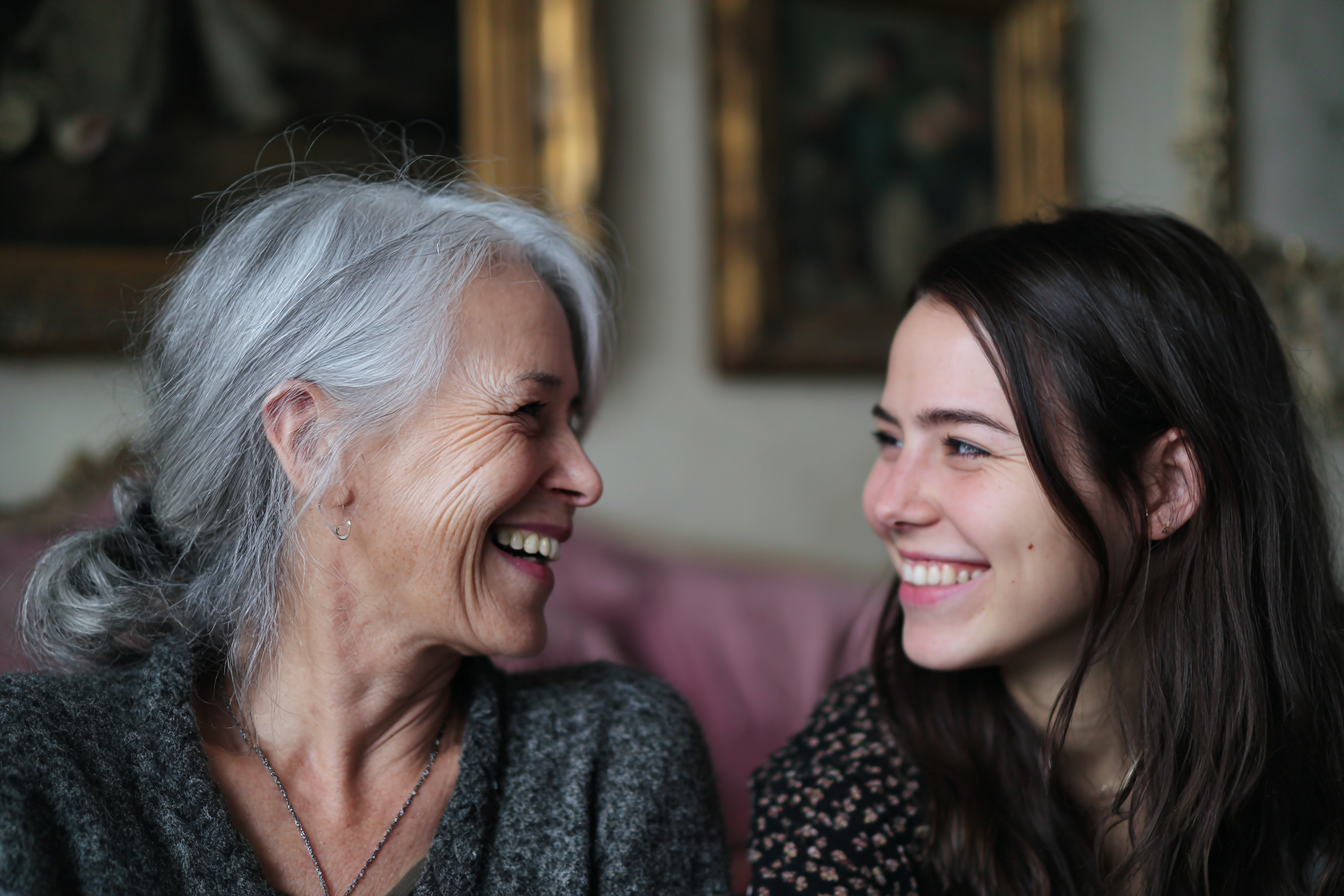 Two women giggling together | Source: Midjourney