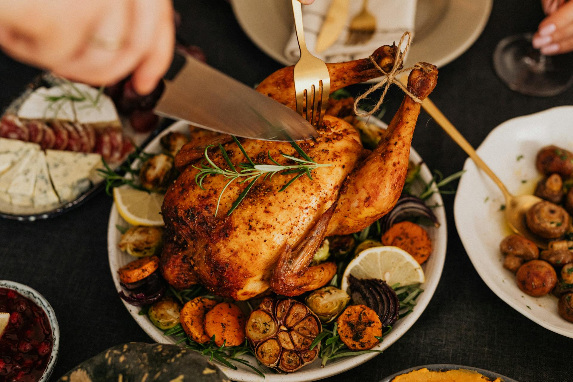 A person cutting roasted chicken | Source: Pexels