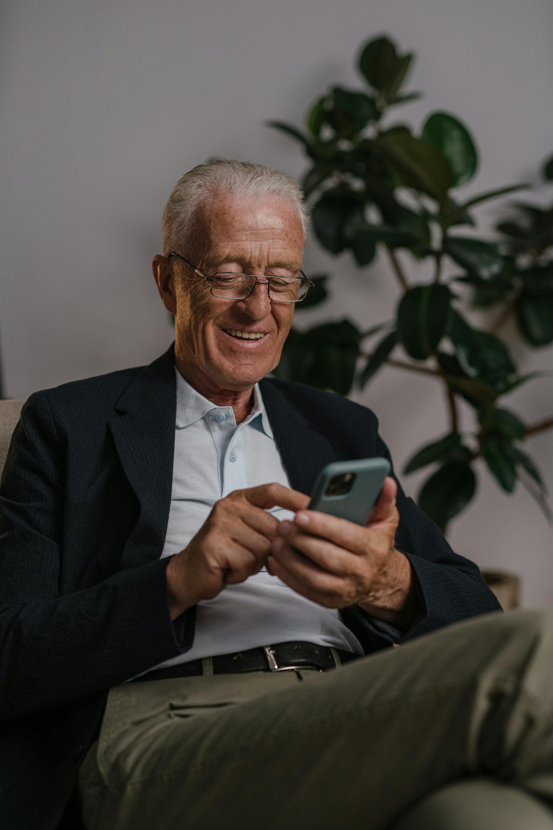 A man sitting using his phone | Source: Pexels