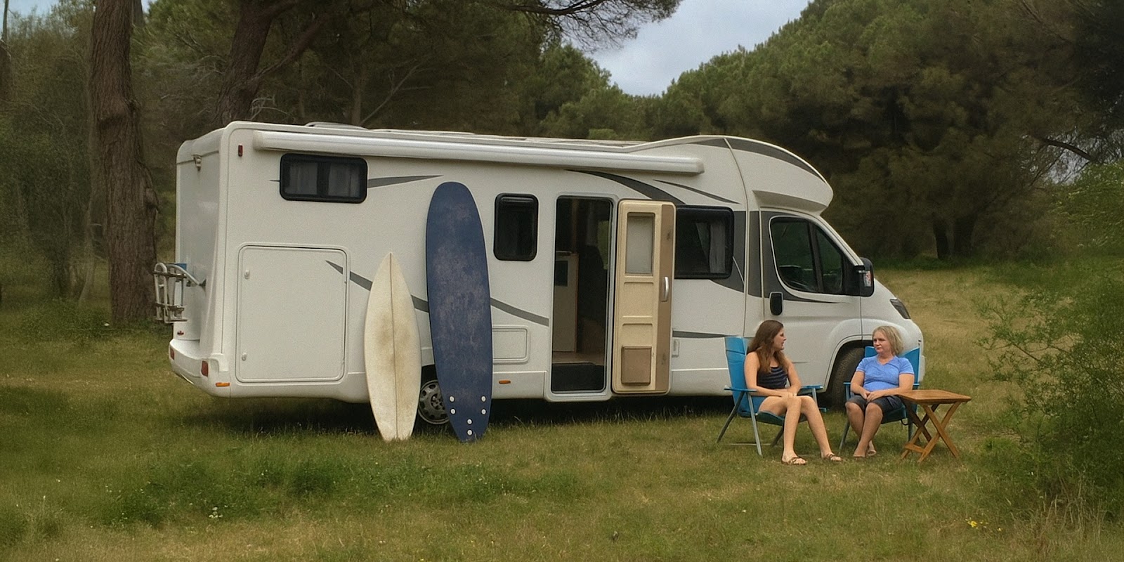 Two women near a camping van. | Source: Sora