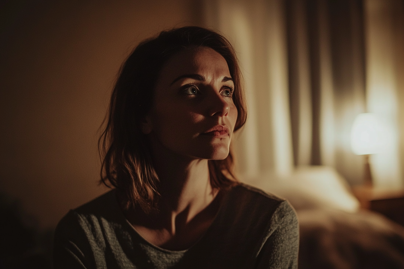 An emotional woman standing in a bedroom at night | Source: Midjourney