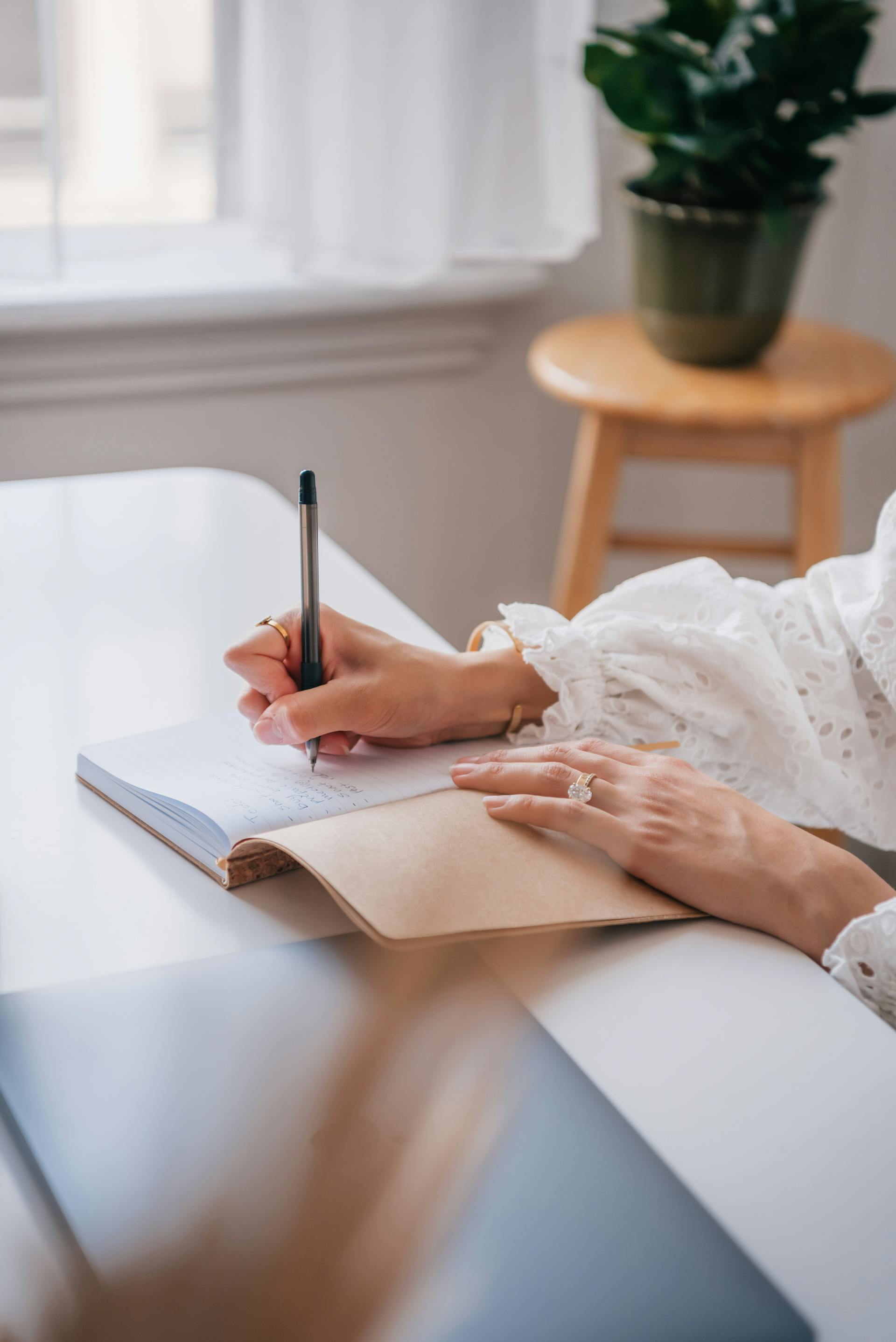 Woman writing on a notebook with a pen | Source: Pexels