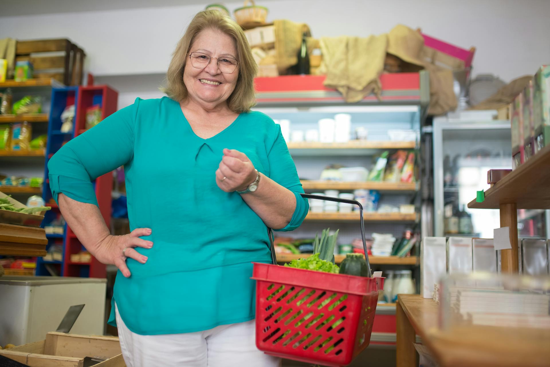 A smiling woman holding a grocery basket in a store | Source: Pexels