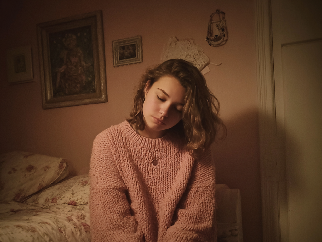 An emotional teenager sitting in a bedroom | Source: Midjourney