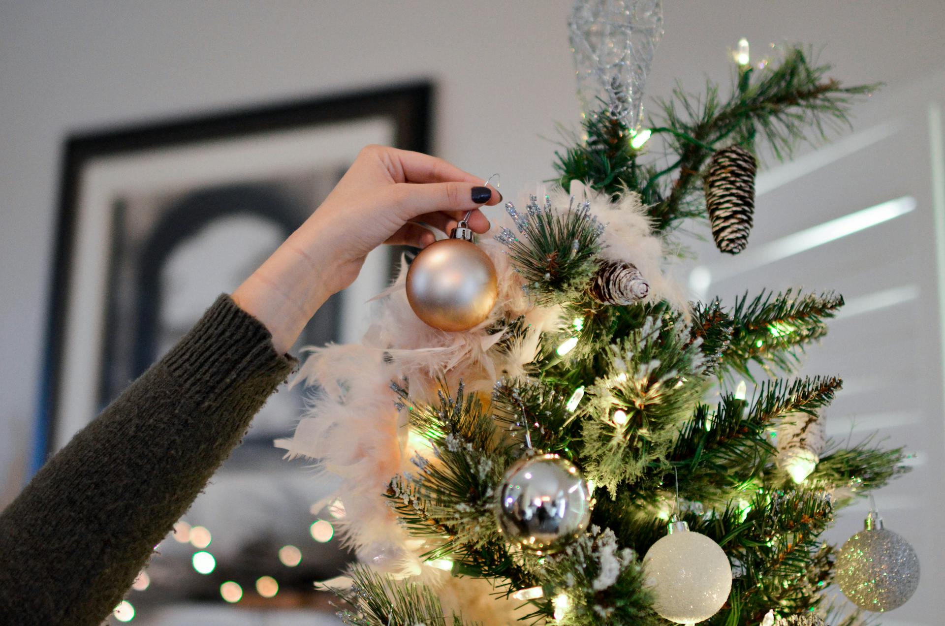 Una mujer decorando un árbol de Navidad | Fuente: Pexels