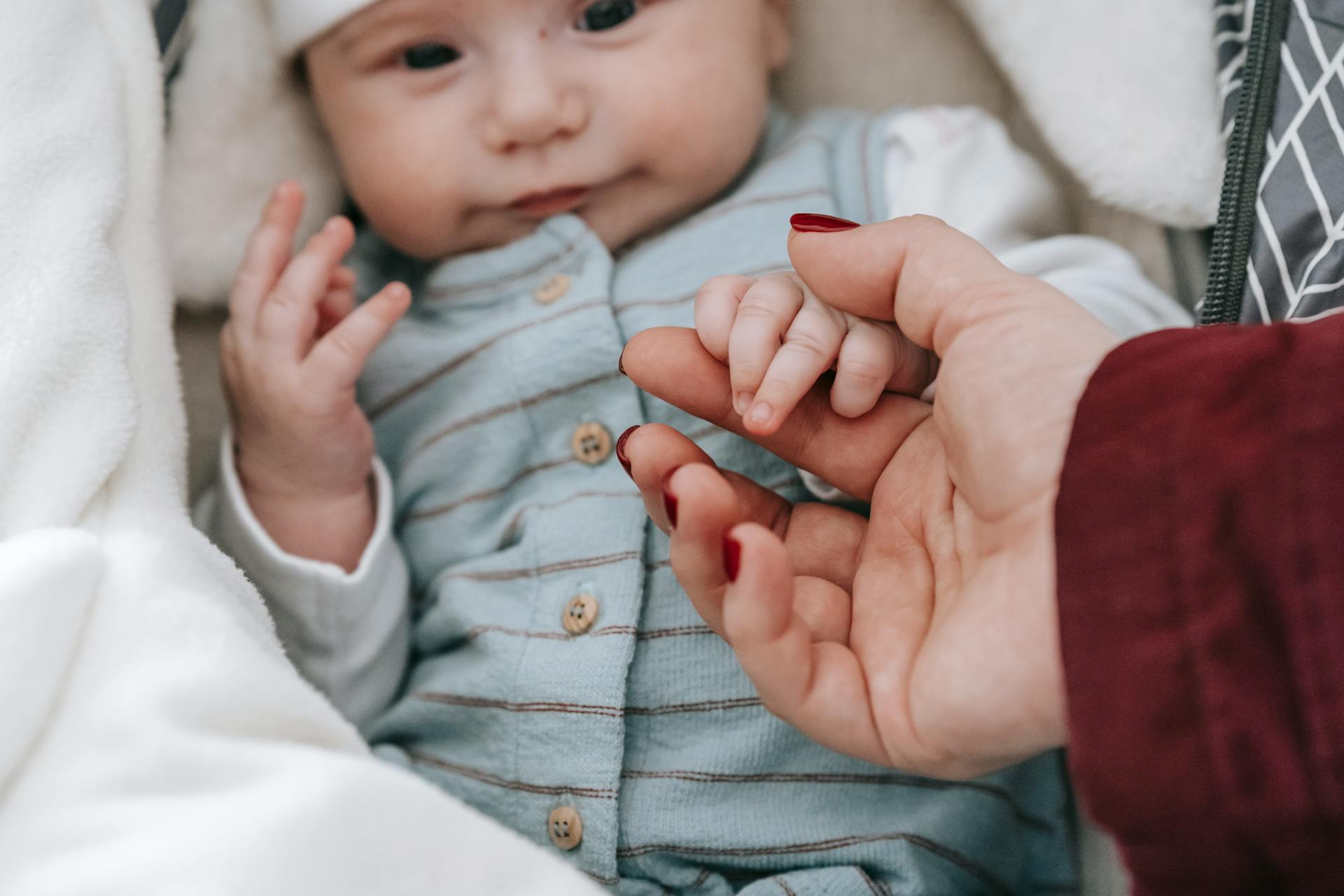 A baby holding his mother's hand | Source: Pexels