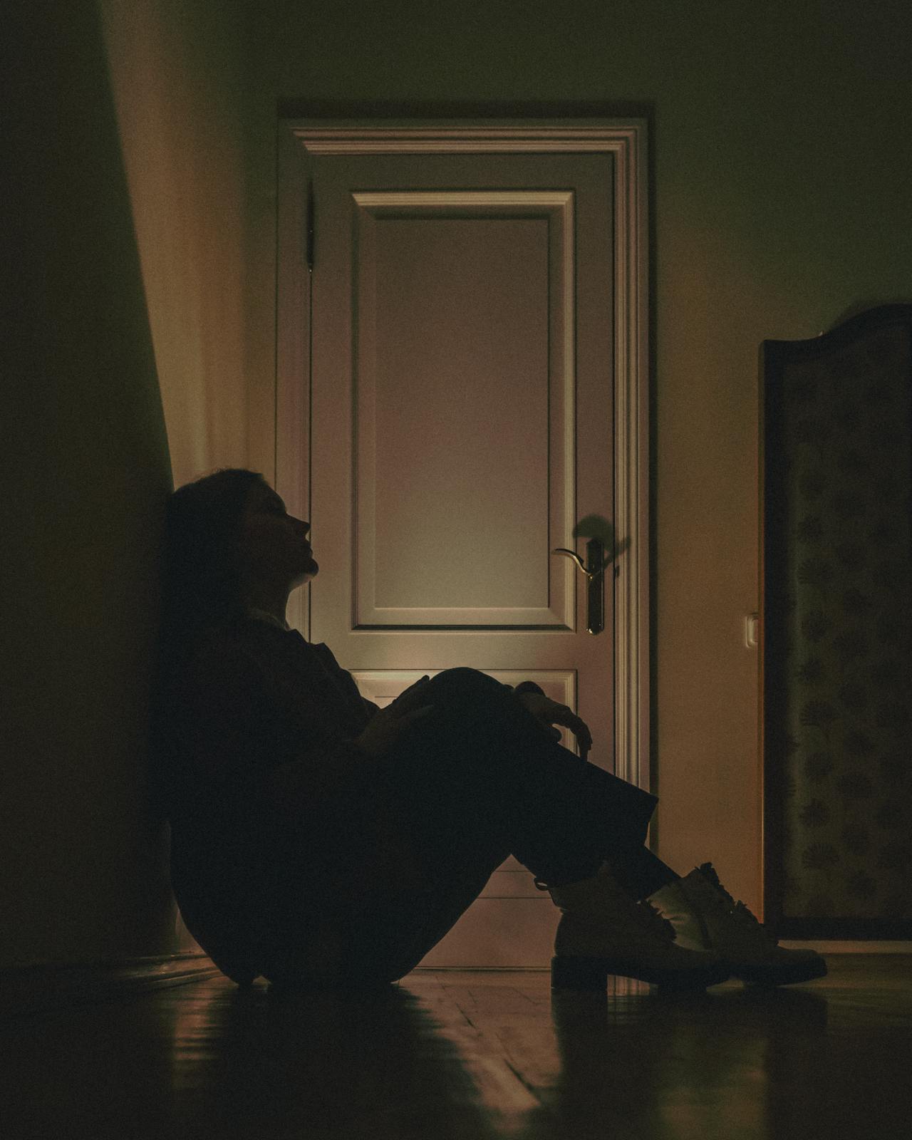 A defeated young lady sitting on the floor | Source: Pexels