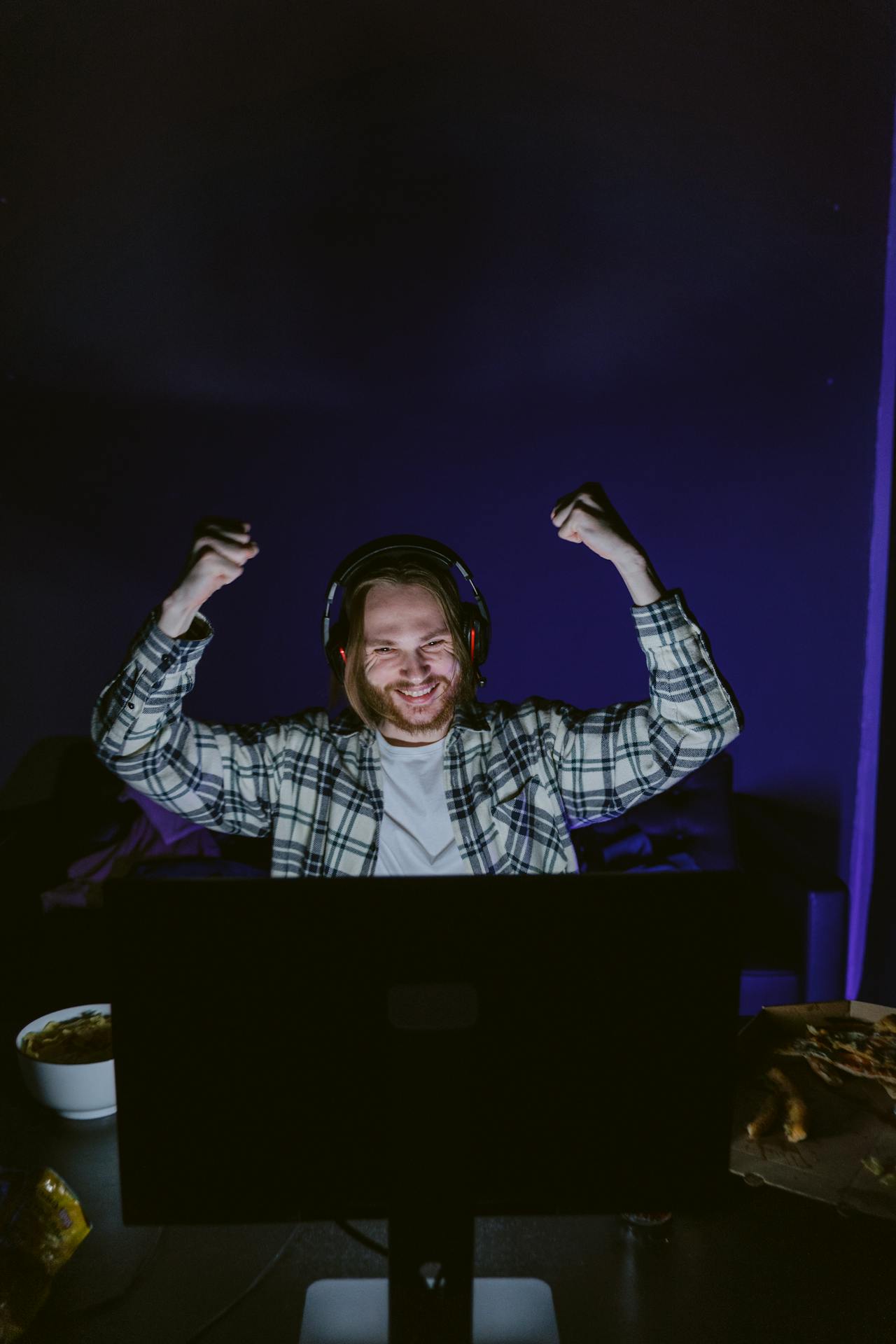 A man using headphones while laughing at the screen | Source: Pexels
