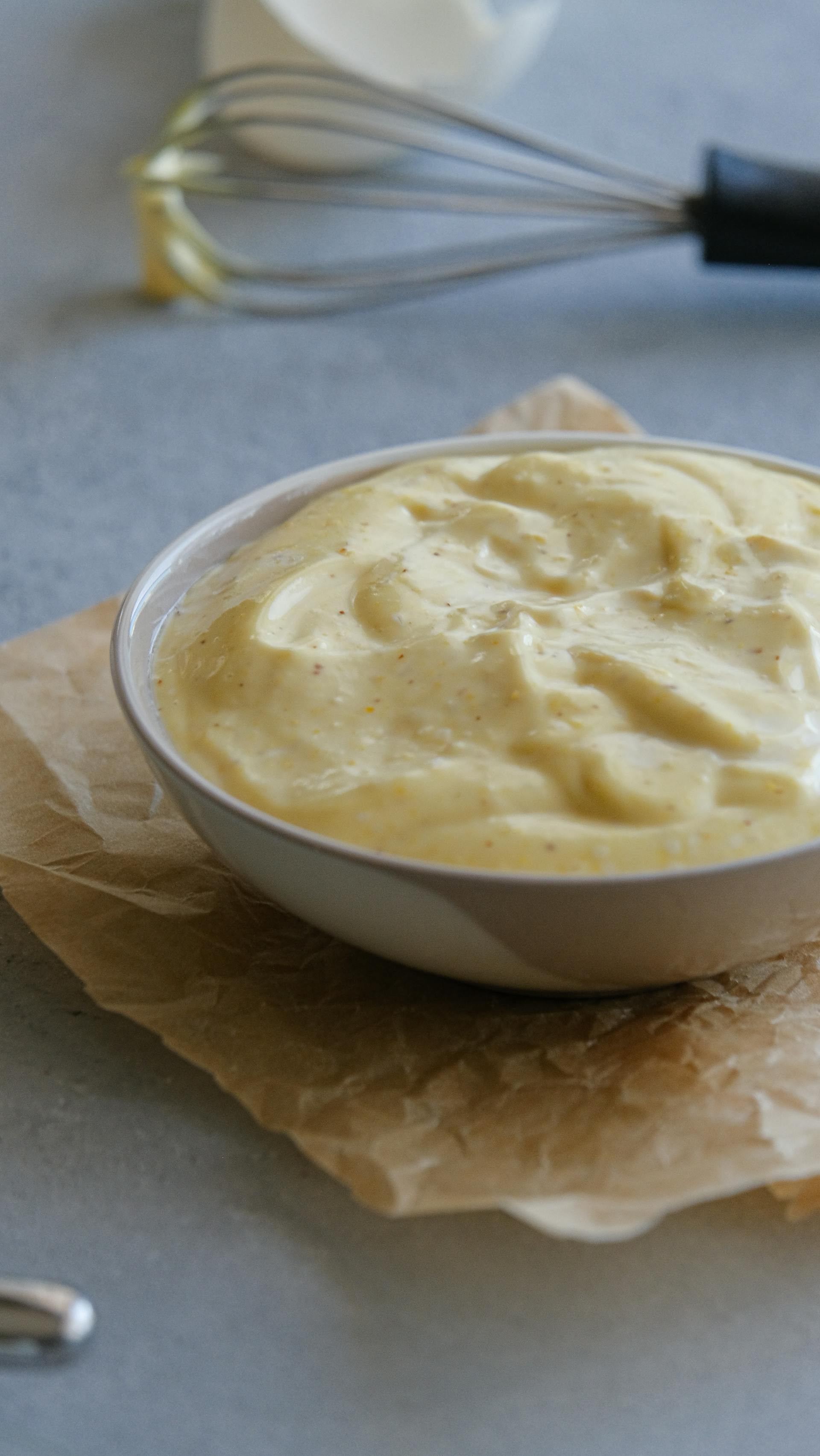 A whisk beside a bowl of dressing | Source: Pexels