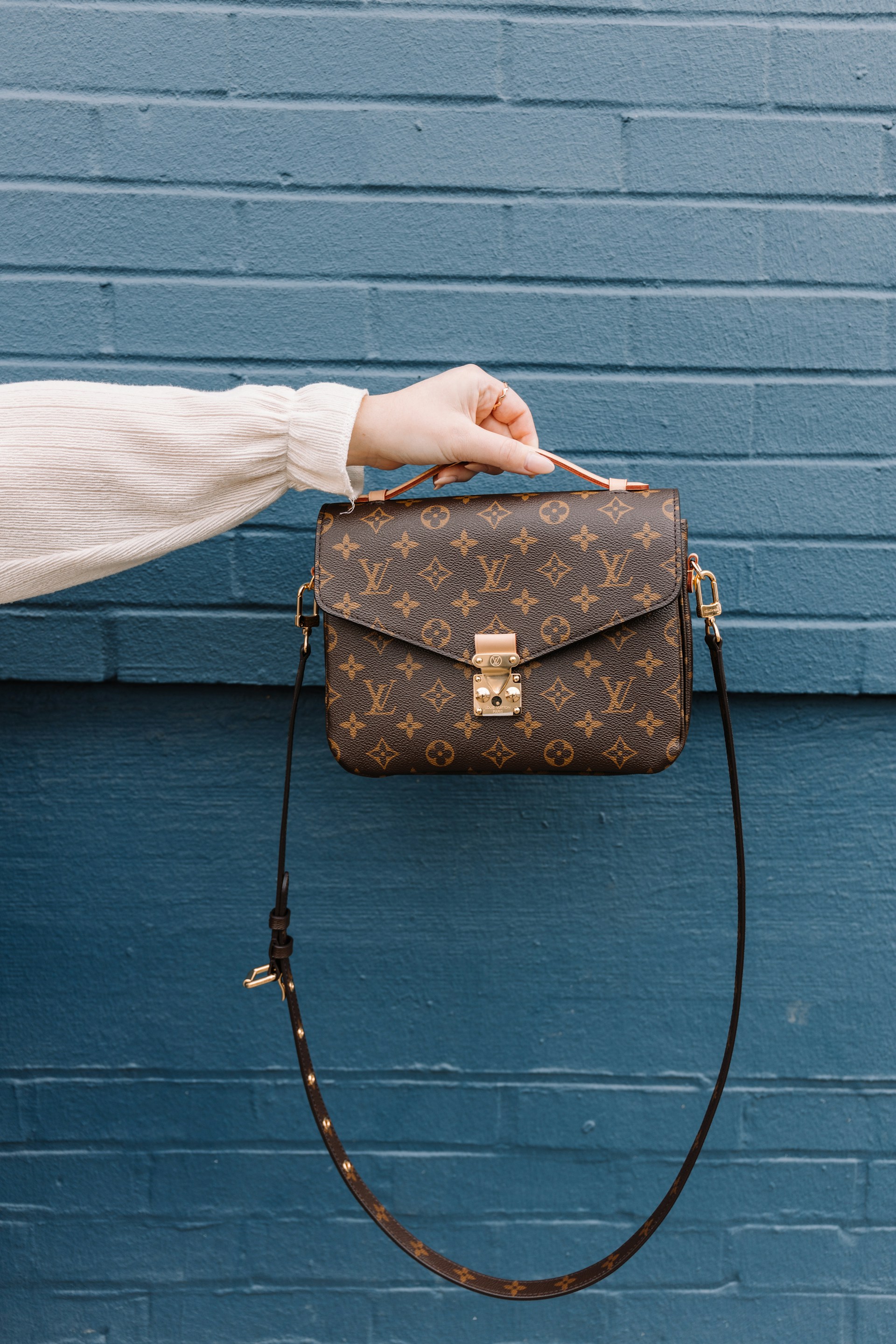 Woman flaunting a designer handbag | Source: Unsplash