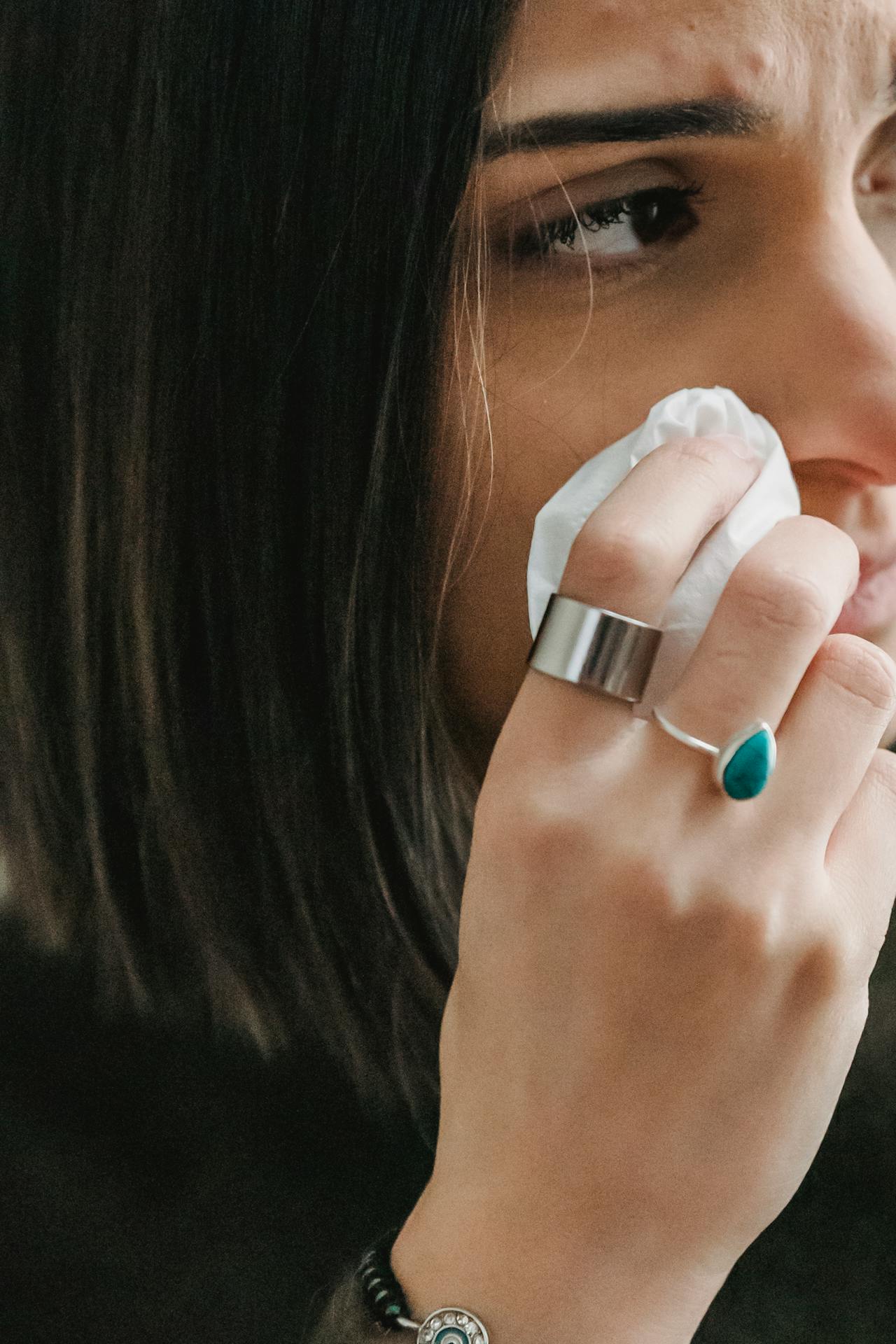 A sad woman wiping her face with tissue paper | Source: Pexels