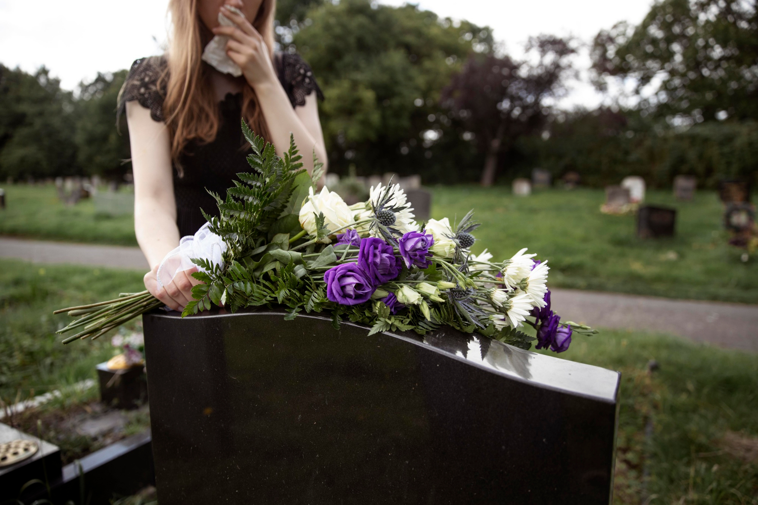 A grieving woman visiting a loved one's grave | Source: Freepik