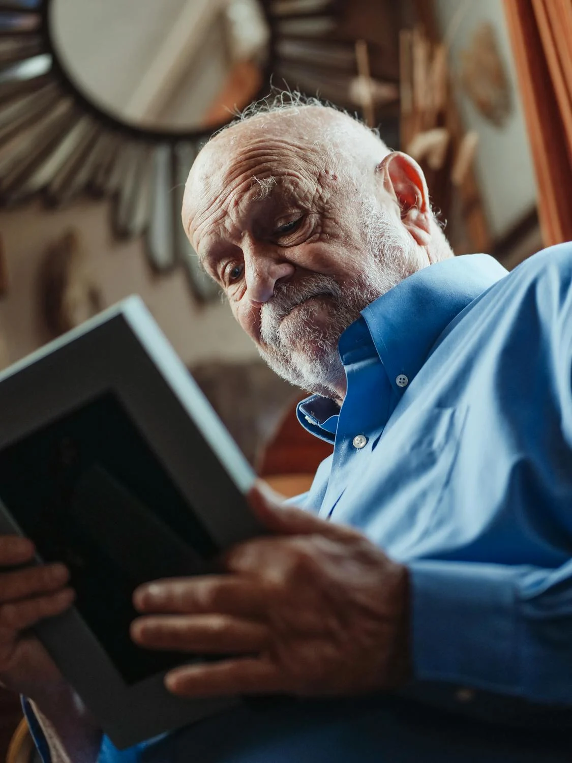 Um homem idoso olhando para uma foto | Fonte: Pexels