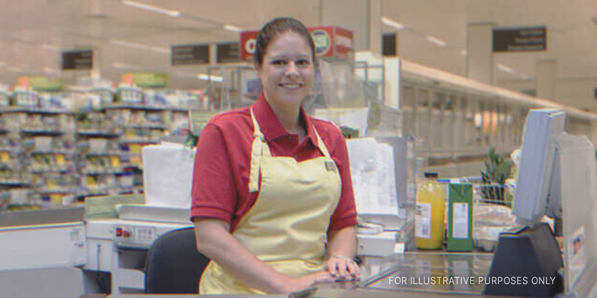 Smiling cashier sits at checkout station | Source: Getty Images