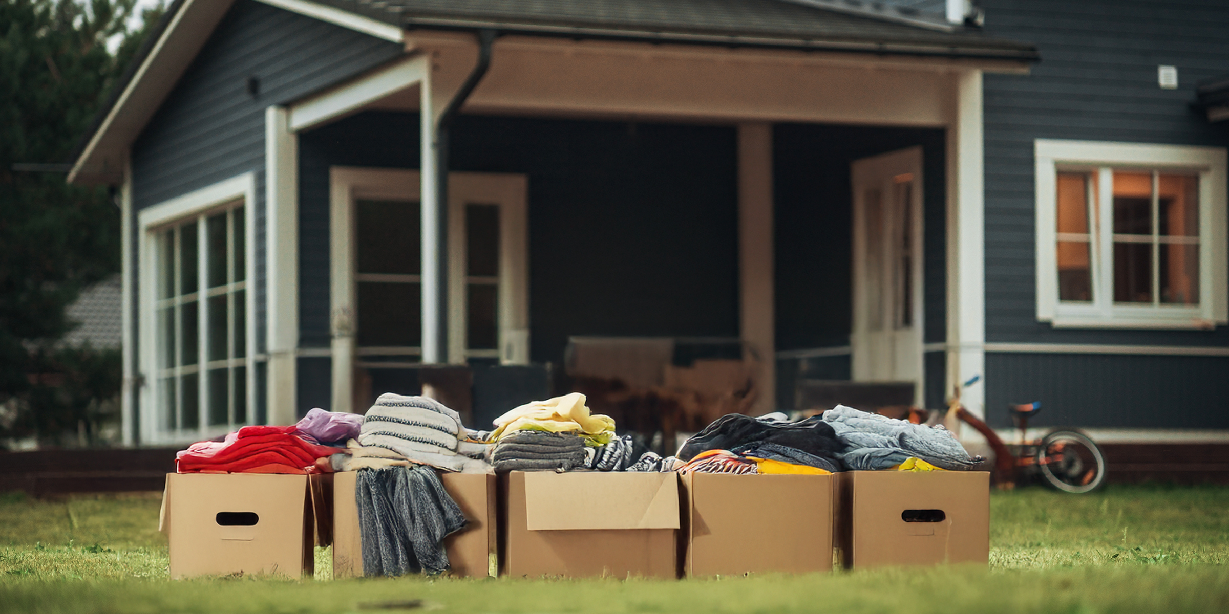 A pile of clothes in boxes stacked outside a house | Source: Shutterstock