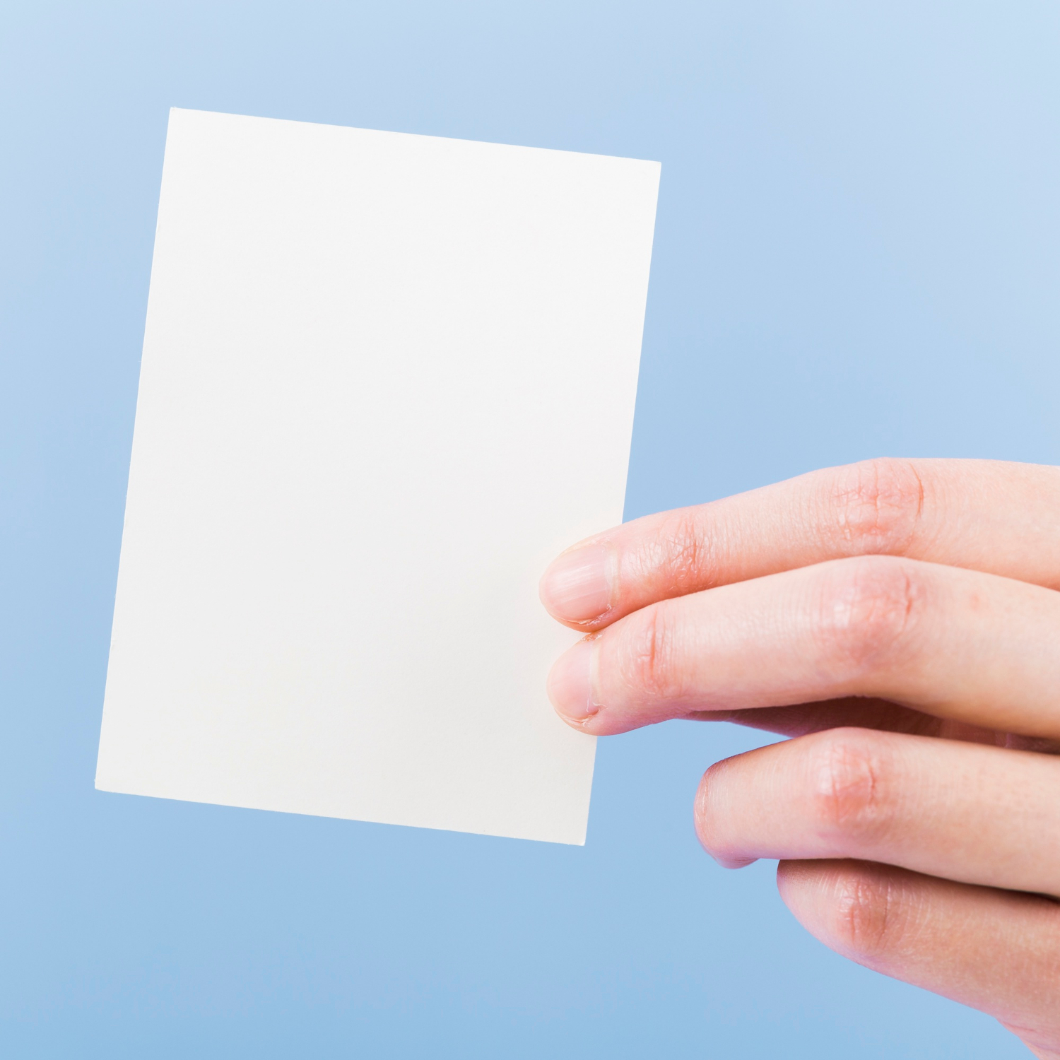 Close-up shot of a person holding a piece of paper | Source: Freepik