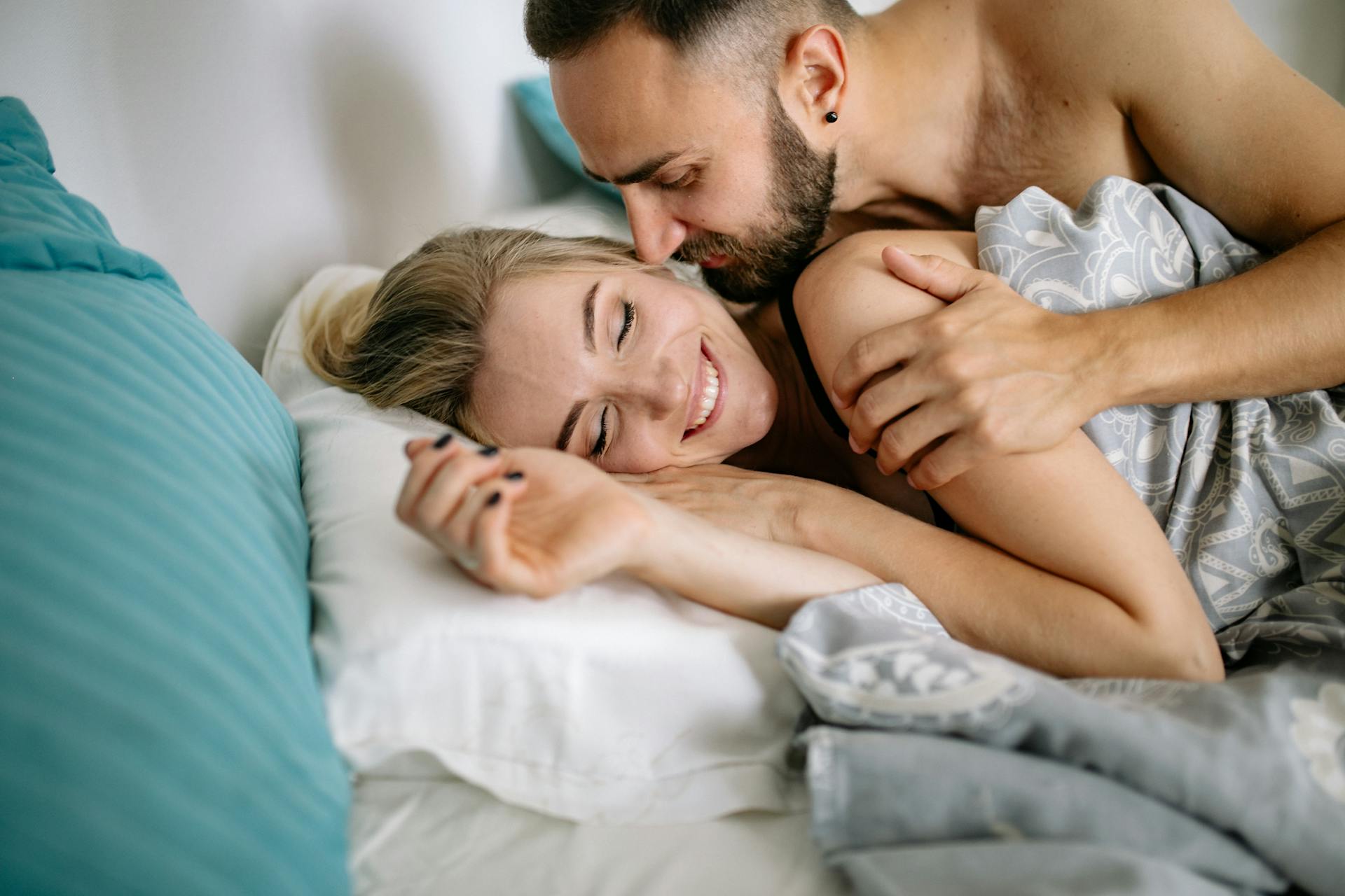 A man embracing a woman in bed | Source: Pexels
