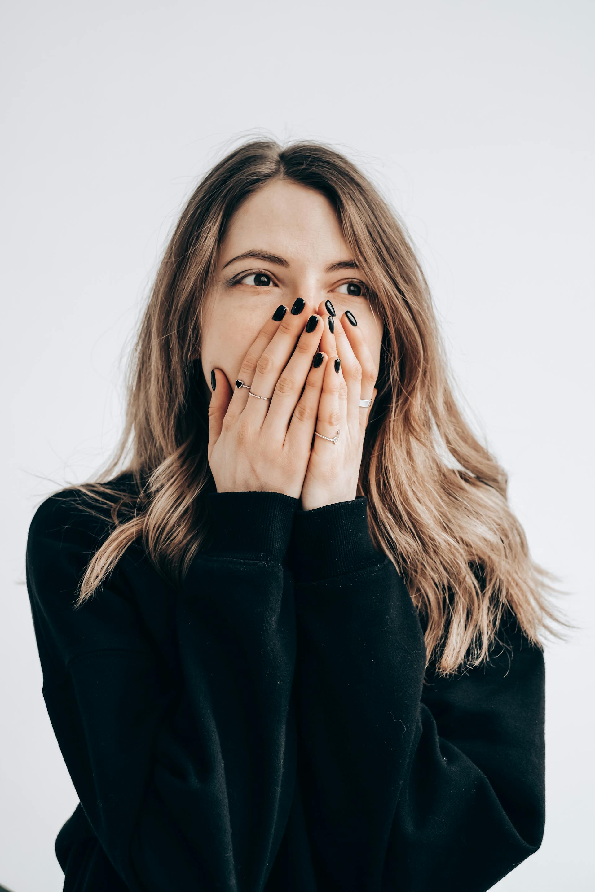 A startled young woman covering her mouth | Source: Pexels