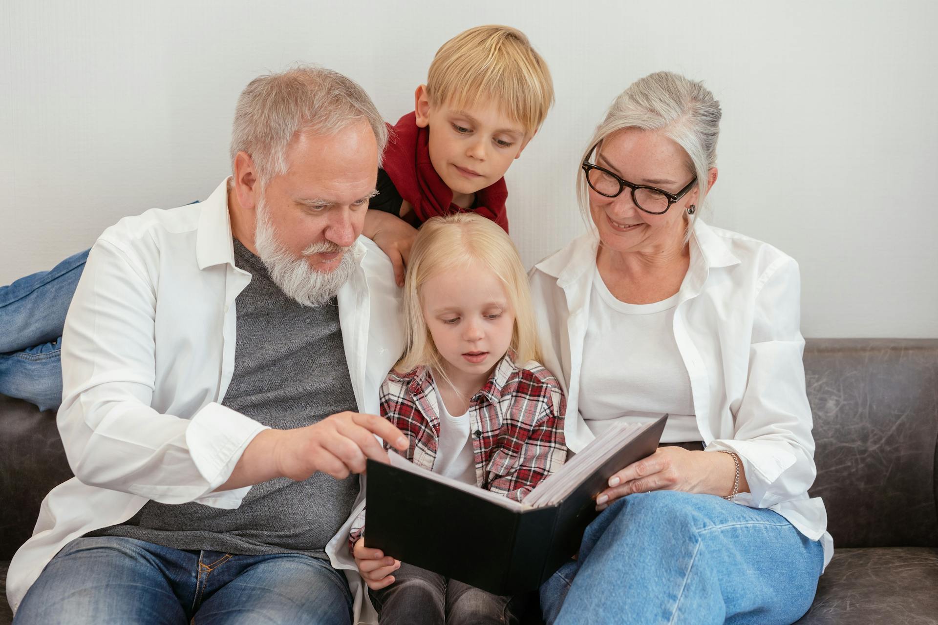 Grandparents looking at a photo album with their grandkids | Source: Pexels