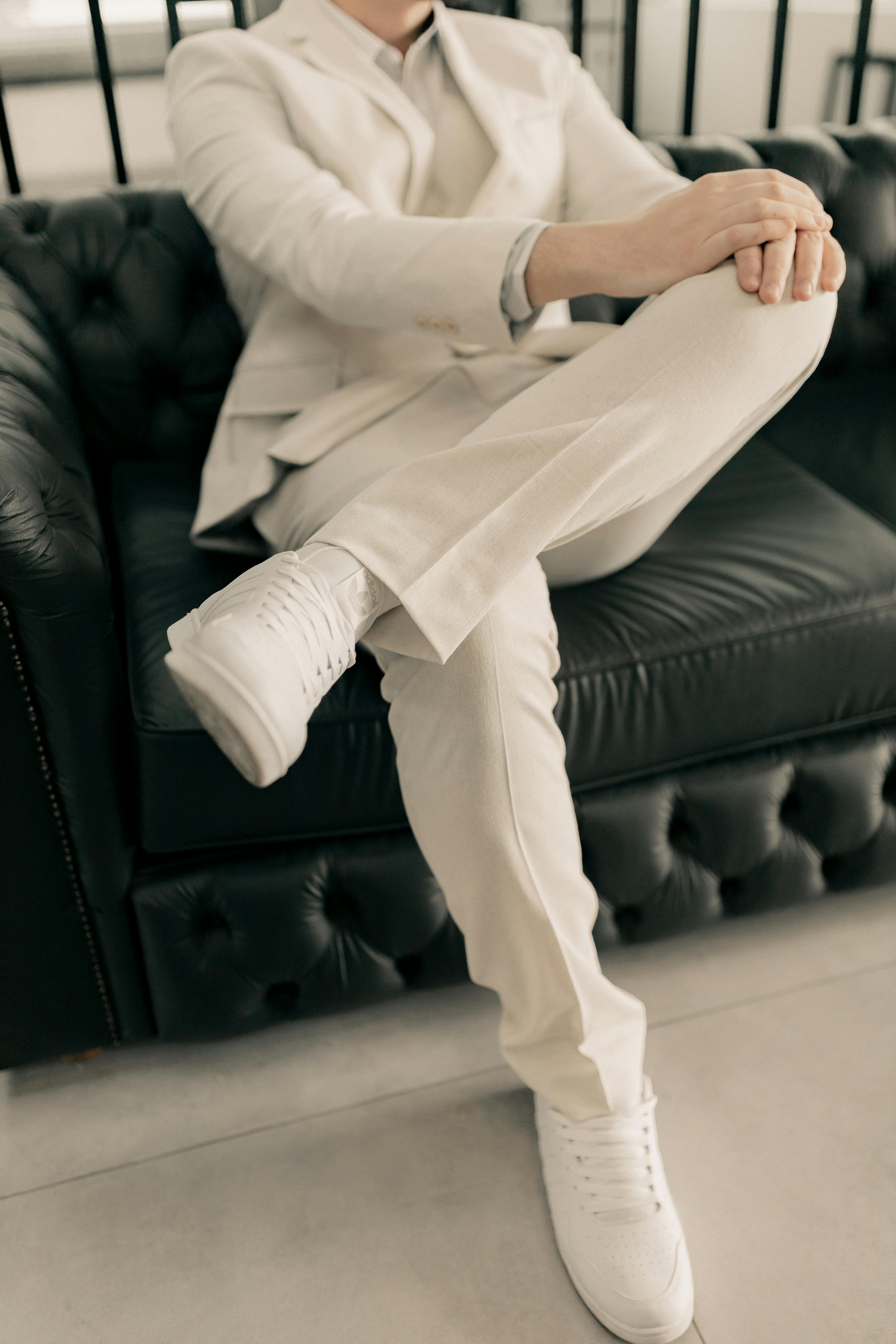 Person in a beige suit seated on a leather sofa | Source: Pexels