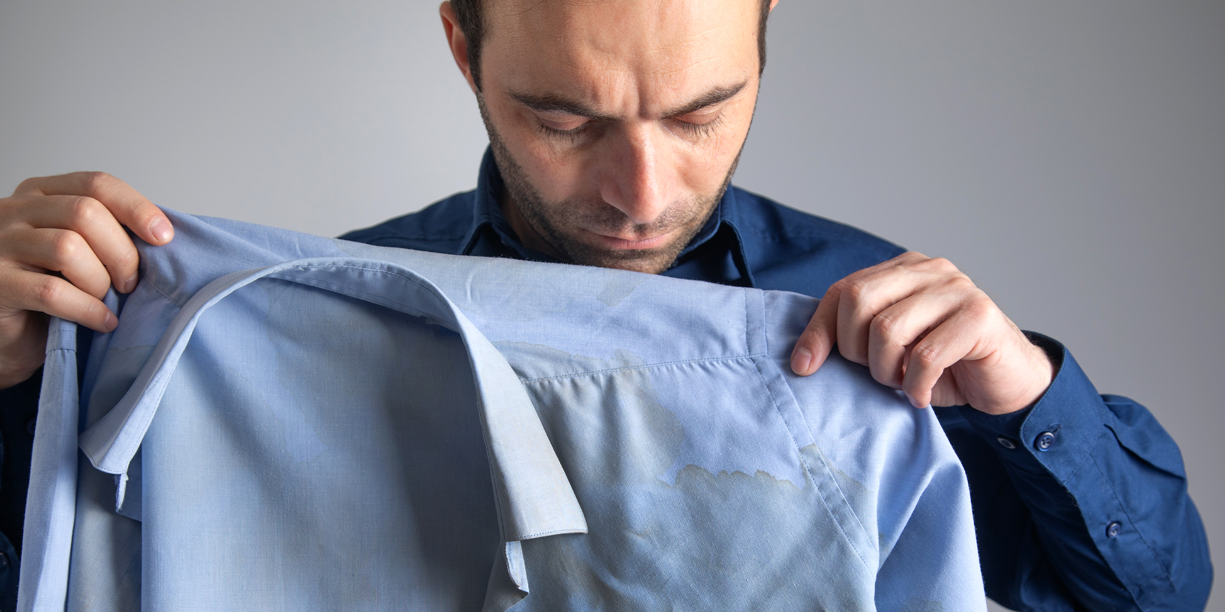 A man holding a stained shirt | Source: Shutterstock