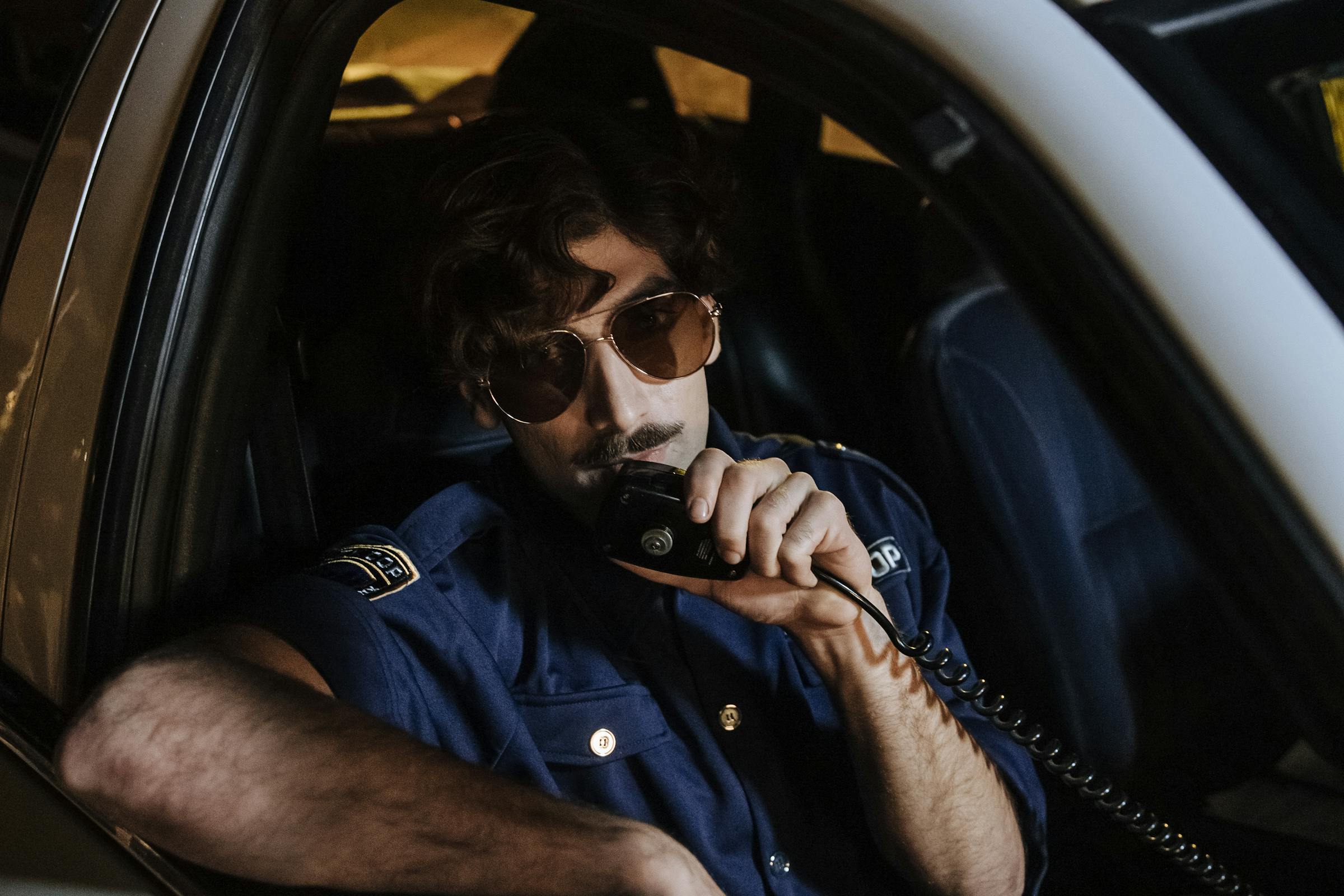 Police officer using the intercom in a patrol car | Source: Pexels