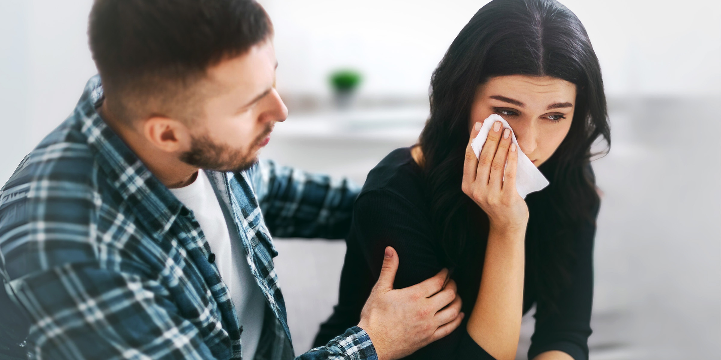 A man comforting a crying woman | Source: Shutterstock