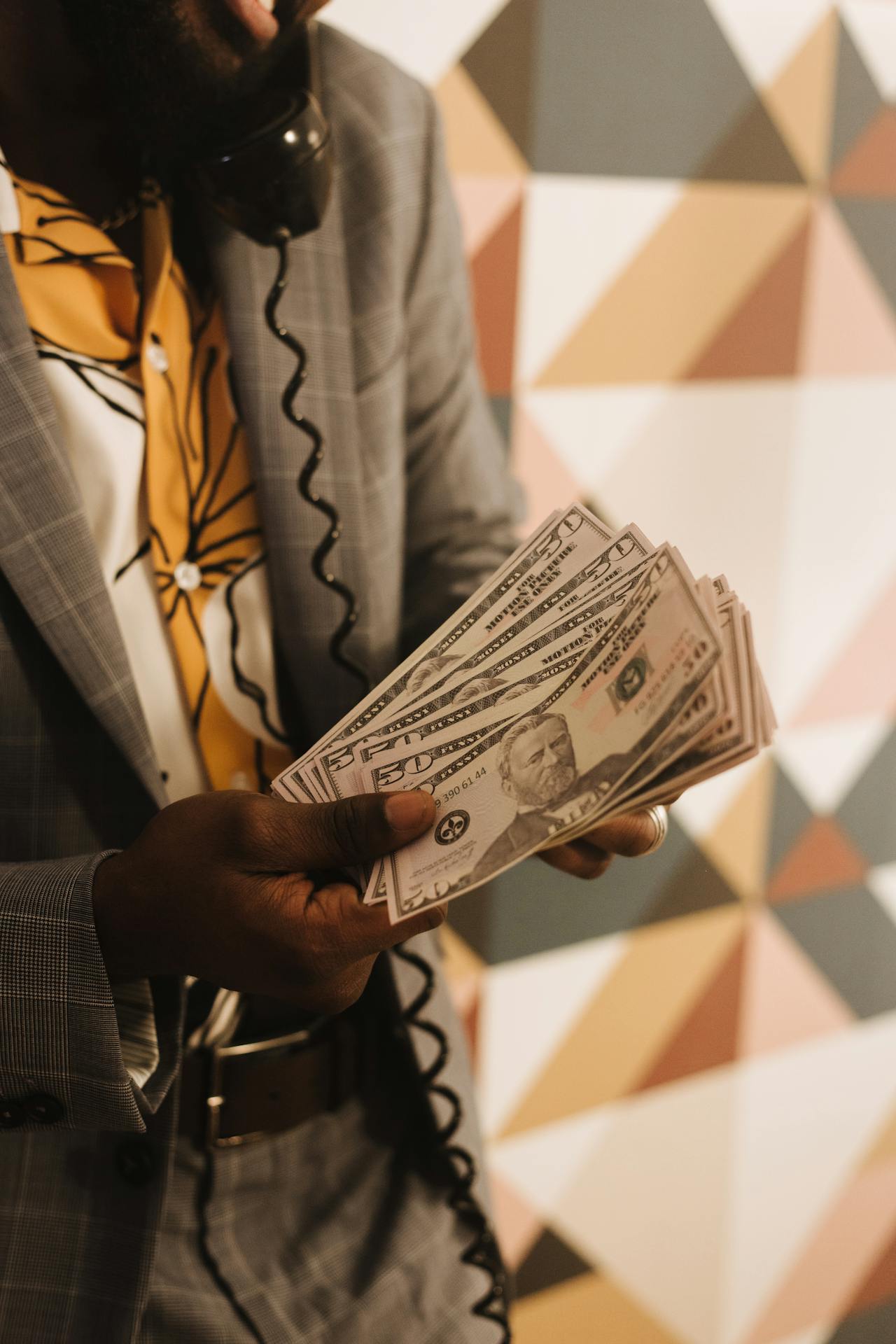 A man talking on the telephone while holding money | Source: Pexels