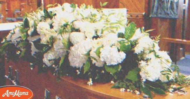 A coffin with flower on top of it | Source: Shutterstock