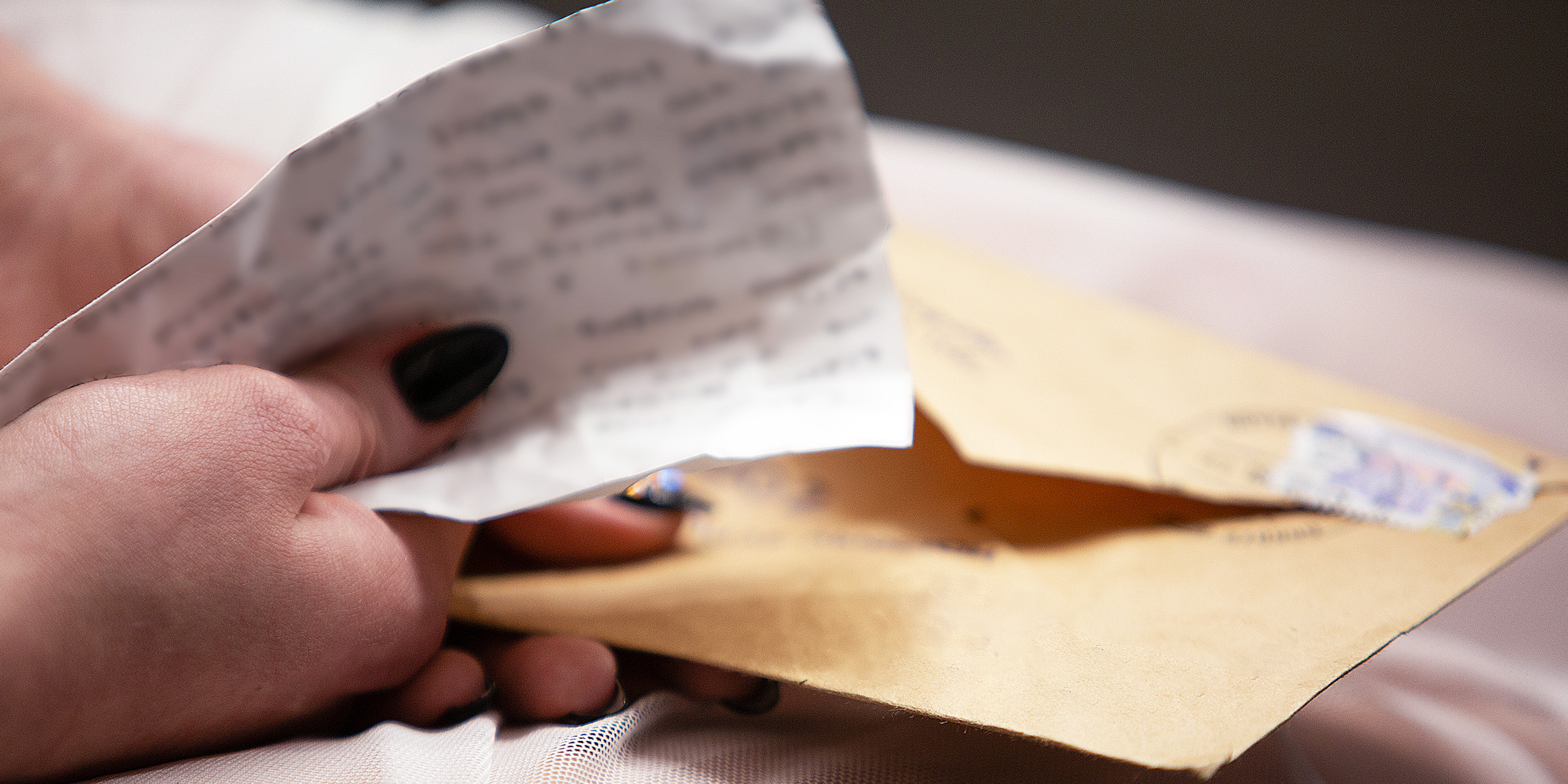 A person holding an envelope and a letter | Source: Shutterstock