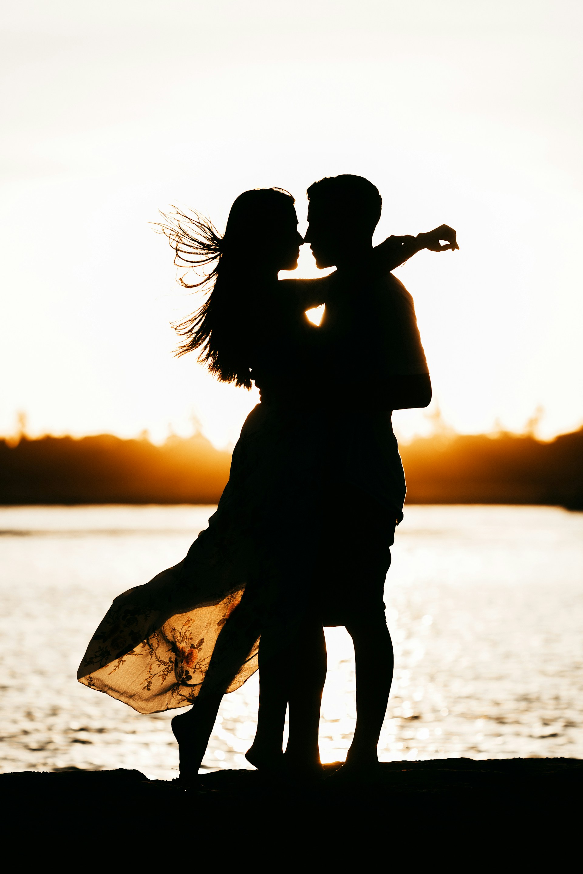 Silhouette d'un couple romantique au bord de la mer | Source : Unsplash