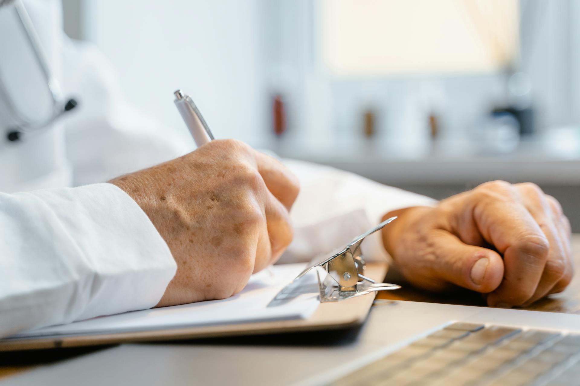 A doctor writing on a paper | Source: Pexels