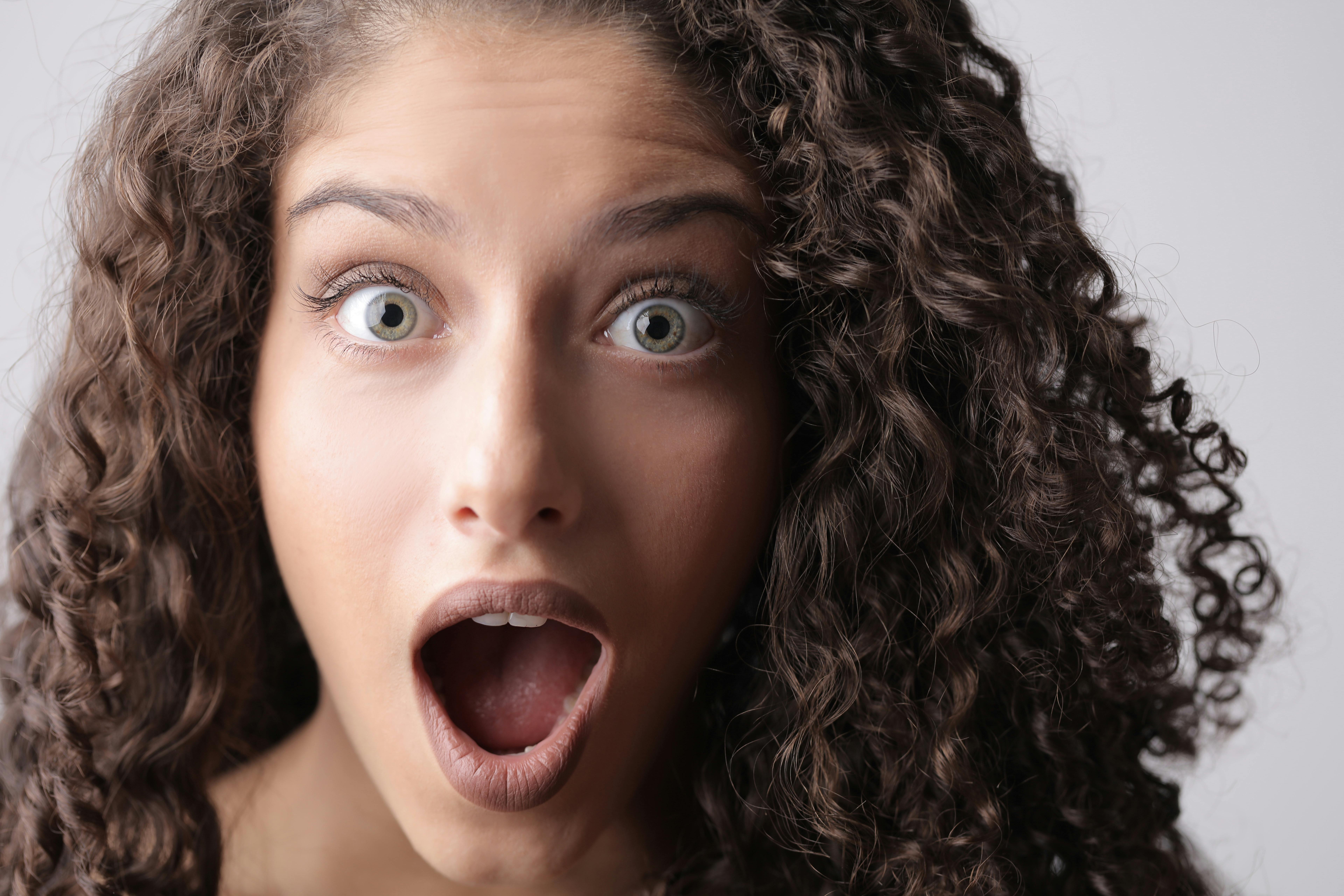 A shocked woman with curly hair | Source: Pexels