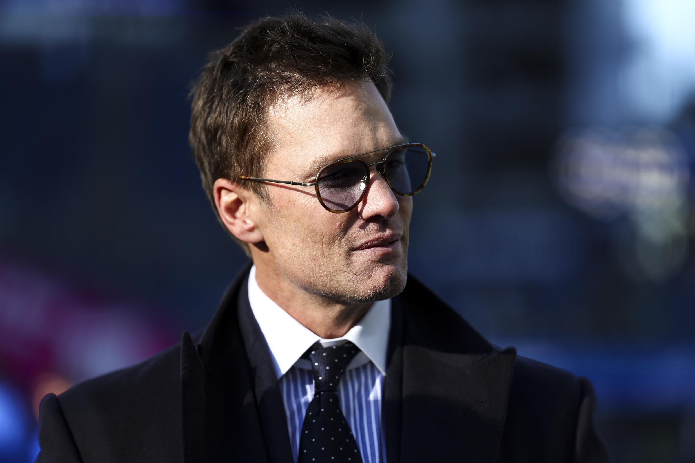 Tom Brady stands on the field prior to the NFC Championship NFL football game between the Seattle Seahawks and the Los Angeles Rams at Lumen Field on January 25, 2026 in Seattle, Washington. | Source: Getty Images