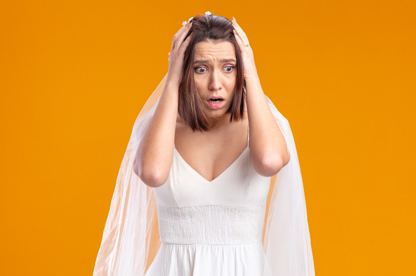 A scared bride clutching her head | Source: Freepik