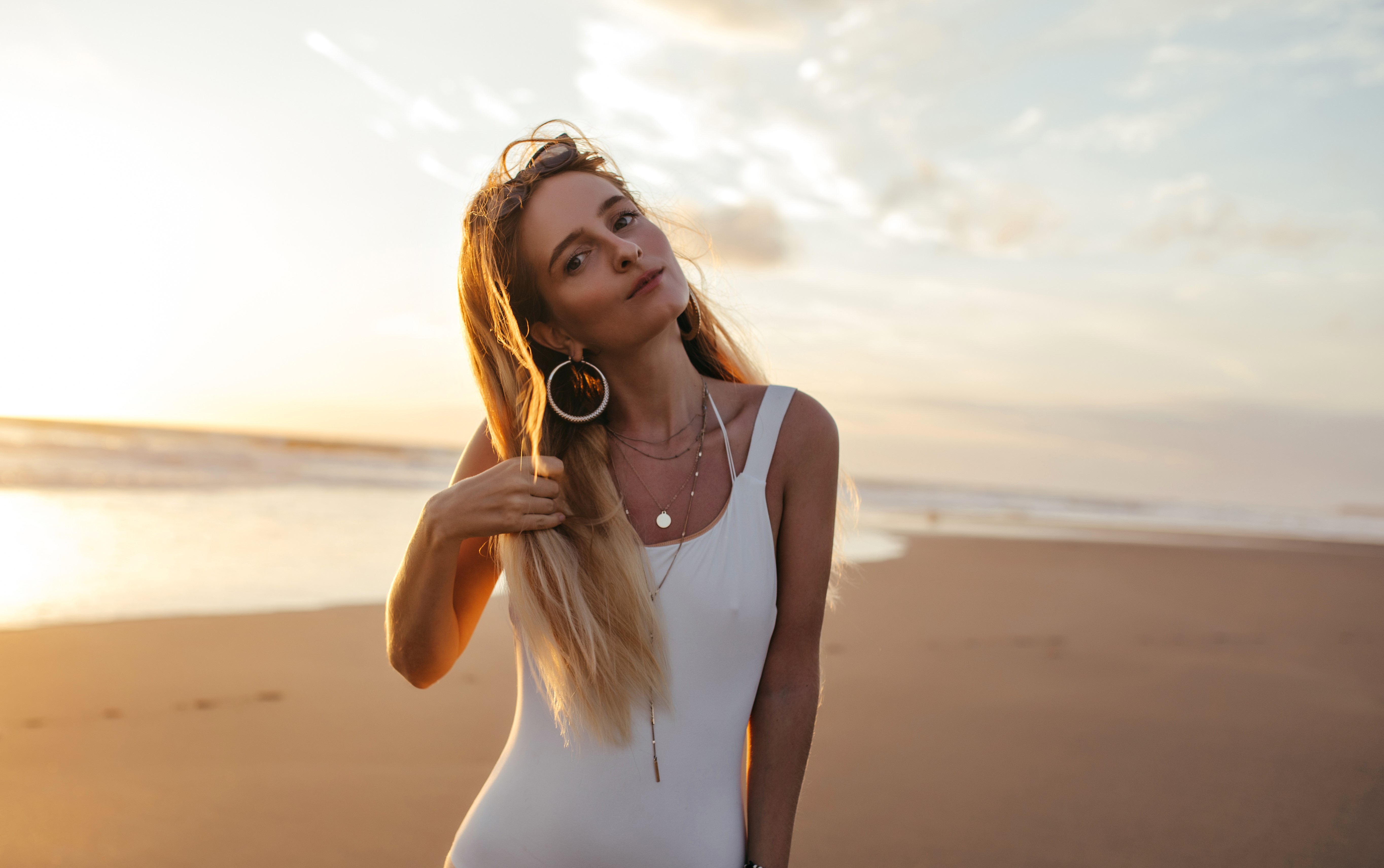 A woman in a swimsuit standing on a sandy beach | Source: Freepik