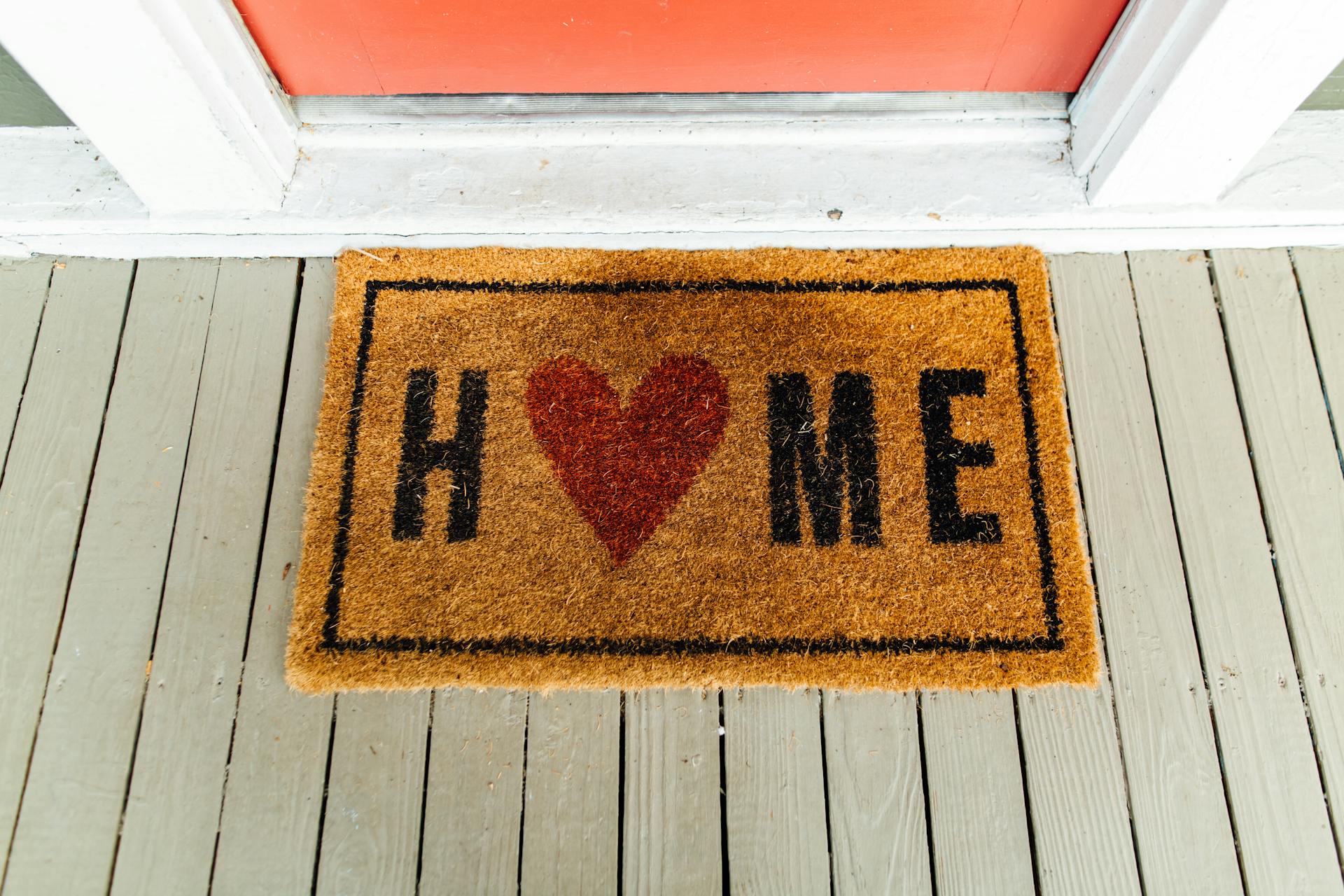 A welcome mat in front of a closed front door | Source: Pexels