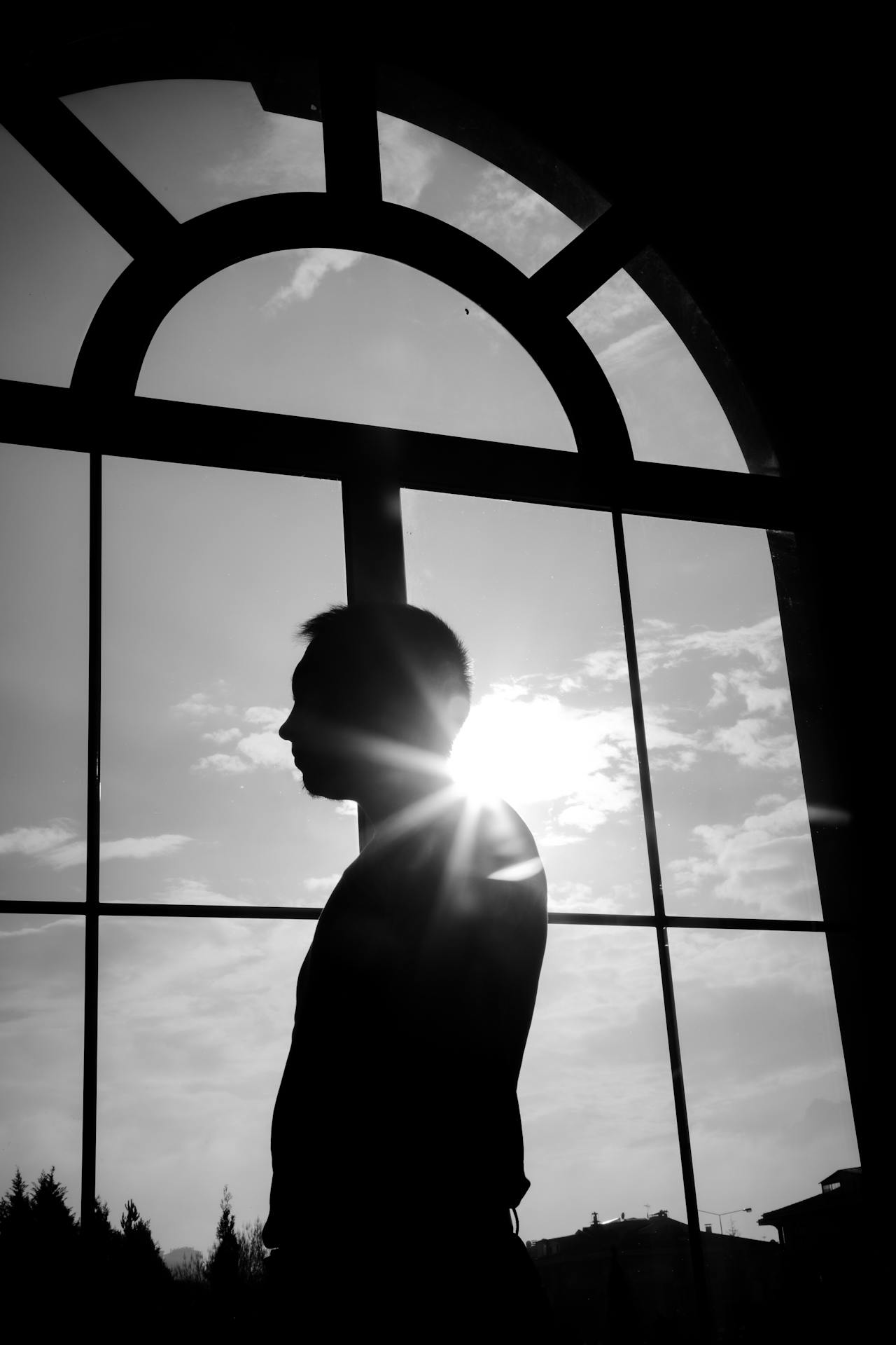 A man standing near an arched window | Source: Pexels