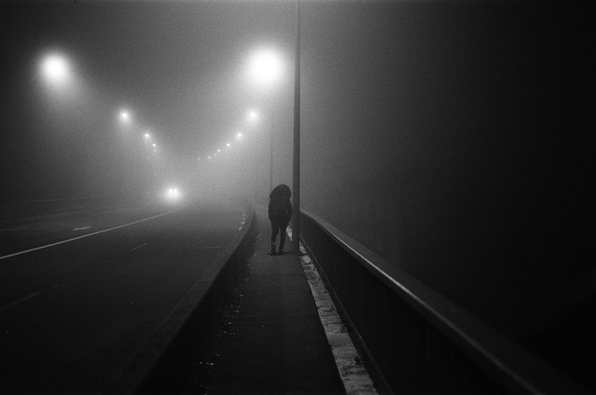 Prise de vue en niveaux de gris d'un homme sur un trottoir | Source : Pexels