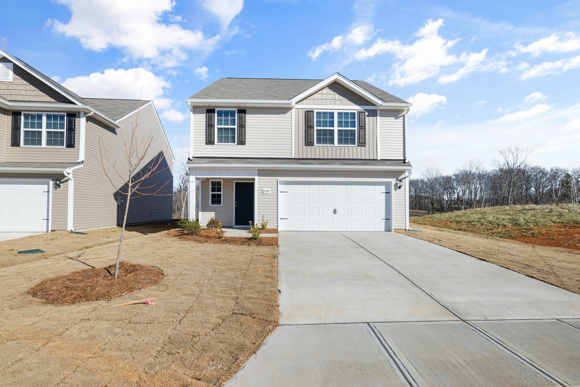 A beige suburban house with brown shutters and a two-car garage | Source: Pexels